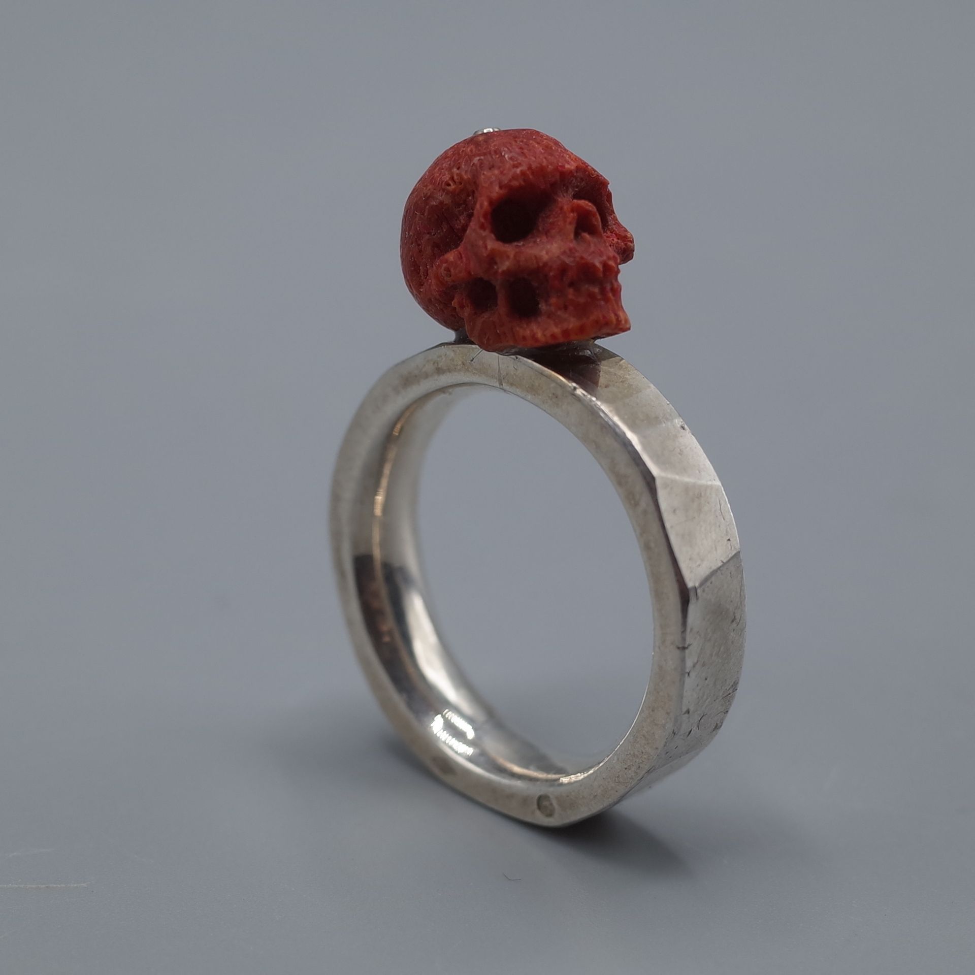 Null 镶嵌有切割红珊瑚的骷髅头和十字骨的银戒指

毛重：12.2克 - 手指大小：63