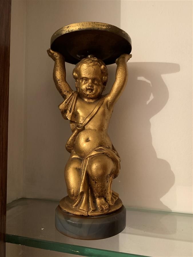 Null Statuette en métal doré représentant un putto à genoux les bras levés. Repo&hellip;