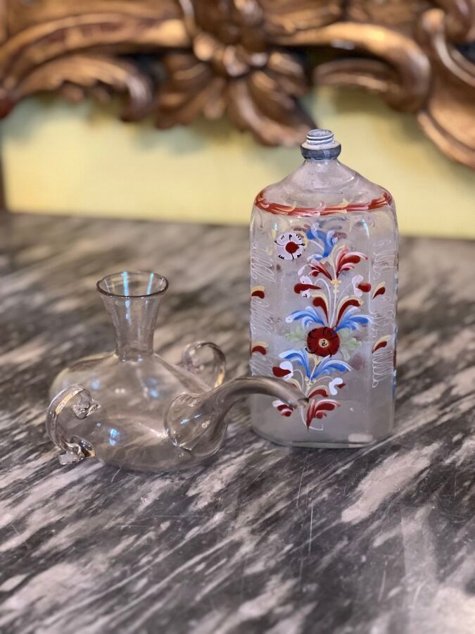 Null 一套包括一个多彩珐琅玻璃瓶和一个吹制玻璃病人瓶（有事故和缺失部分）。
十八和十九世纪。
高度：17 厘米和 10 厘米
