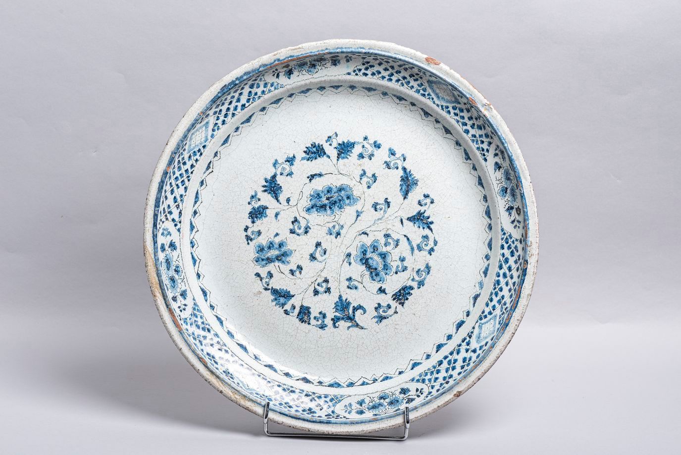 Null 34.一个巴黎或圣克卢的陶器盘子，19世纪上半叶，有蓝色camaïeu装饰。(Chips)。直径：45厘米。