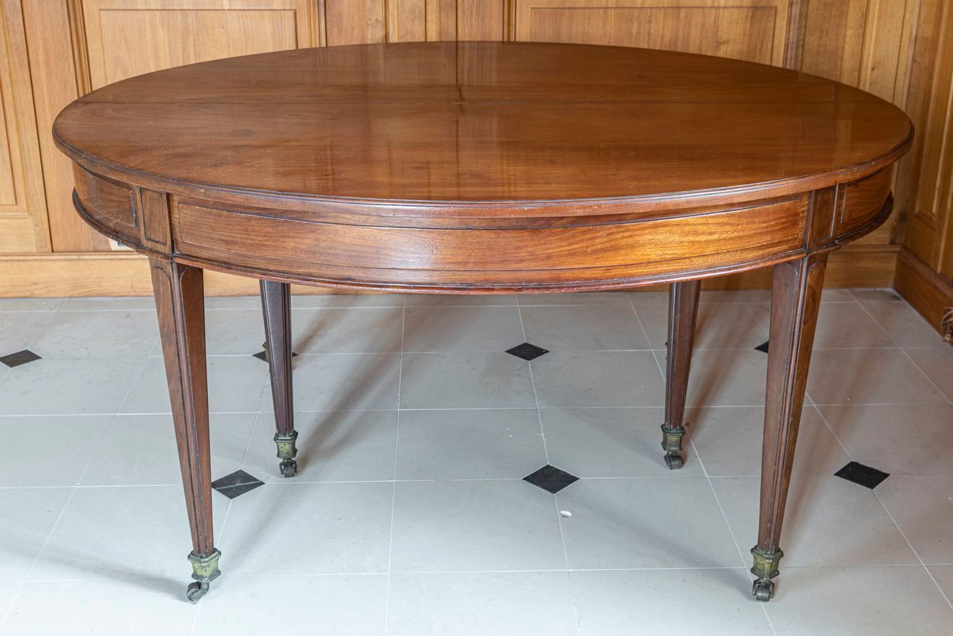 Null 86.一张路易十六风格的六脚桌，19世纪，实心桃花心木，带状的桌面靠在成型的鞘状腿上，末端是铜制的马刀和脚轮。144 x 125厘米。高度：73厘米。&hellip;
