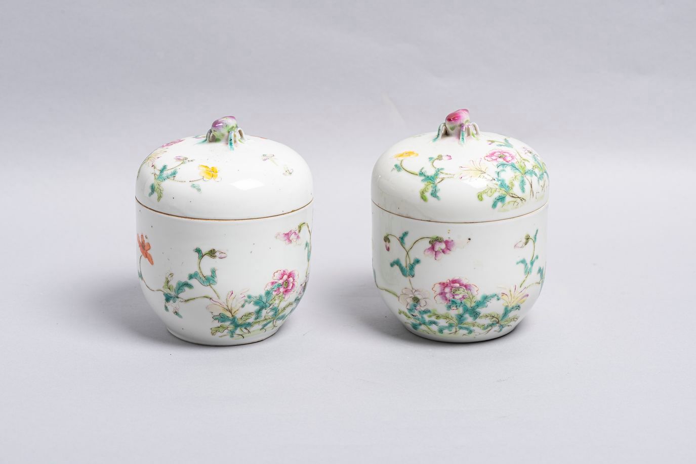 Null 41.一对瓷器盖壶，中国，约1900年，白瓷，用多色珐琅彩装饰的粉彩风格的花和叶，盖子是桃子的形式。 高度：14厘米。