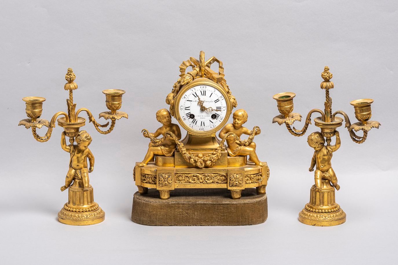 Null 26. Un orologio e una coppia di candelieri in bronzo dorato in stile Luigi &hellip;