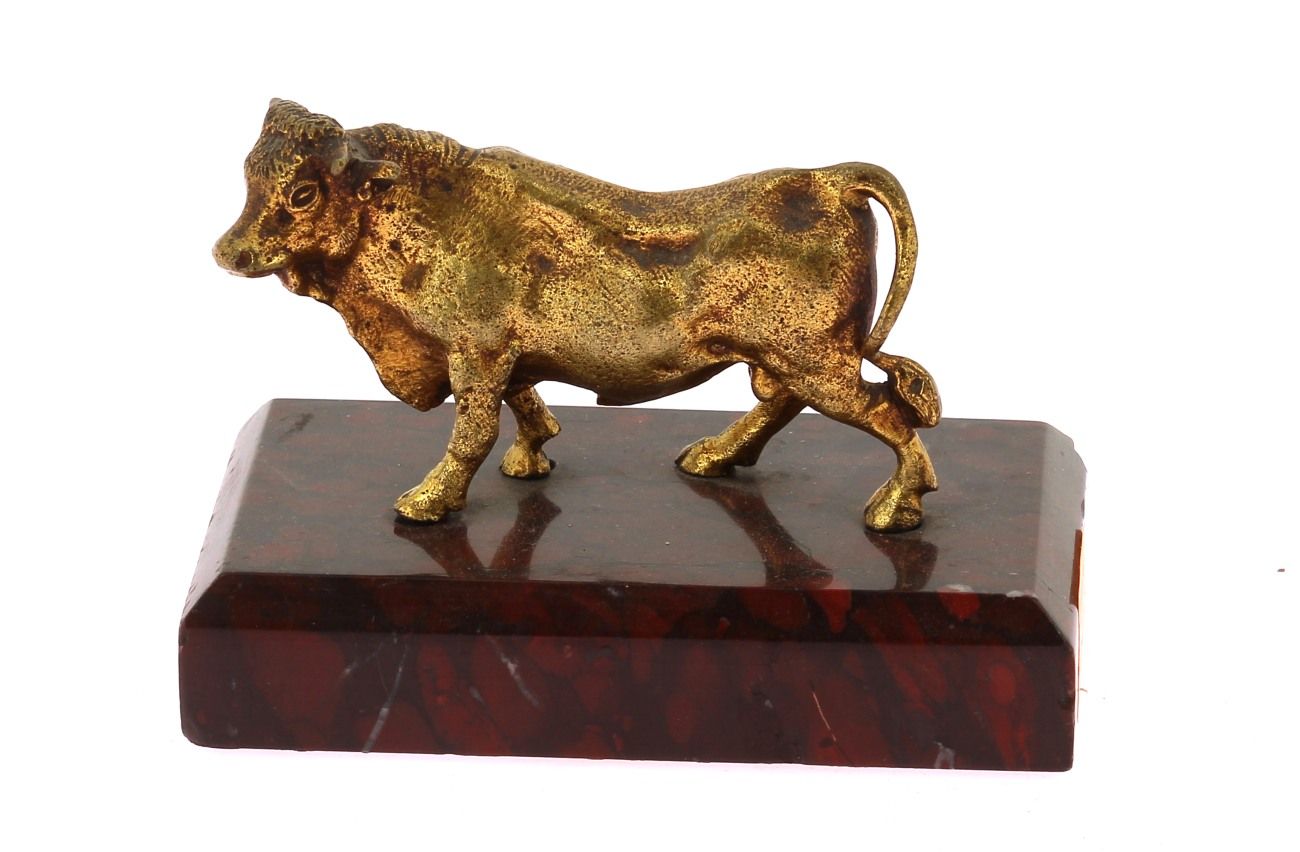 Null "公牛"，镀金青铜主体，高约 5 x 宽约 8 厘米，安放在长方形红色大理石底座上（两角有缺口，高 7.5 x 宽 10.5 厘米）。
