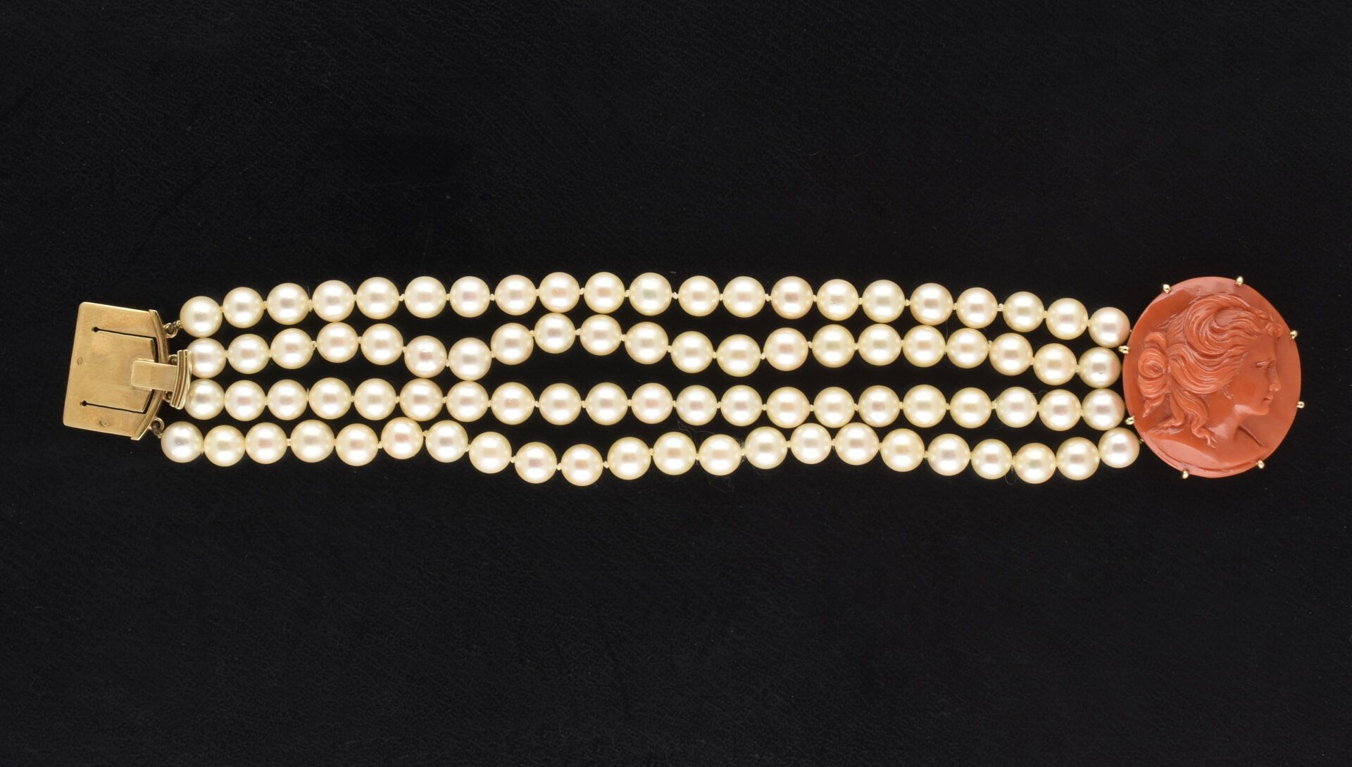 Null 镶嵌 85 颗白色养殖珍珠的 4 排手链，黄金搭扣上饰有一个珊瑚浮雕，浮雕展现了一位女性的半身侧面。
浮雕高度：3.5 厘米
珍珠直径：6.5-7 毫&hellip;