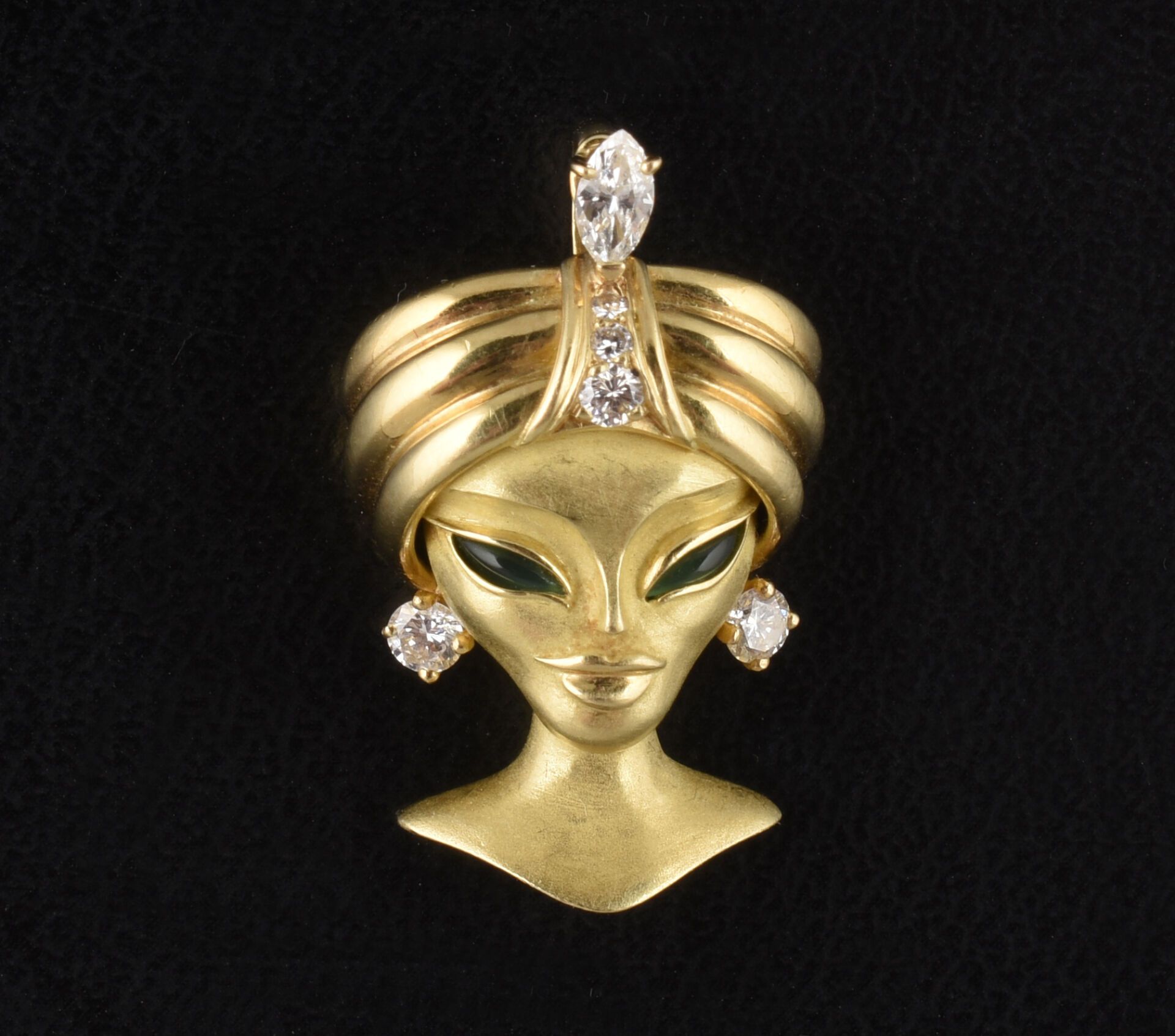 Null 18K 黄金吊坠，饰有一个女人的头像。她头戴头巾，头巾中央有三颗坠落的钻石，上面镶有一颗较大的斜面切割钻石，耳环上镶有圆形钻石。眼睛上镶嵌着凸圆形绿玉&hellip;