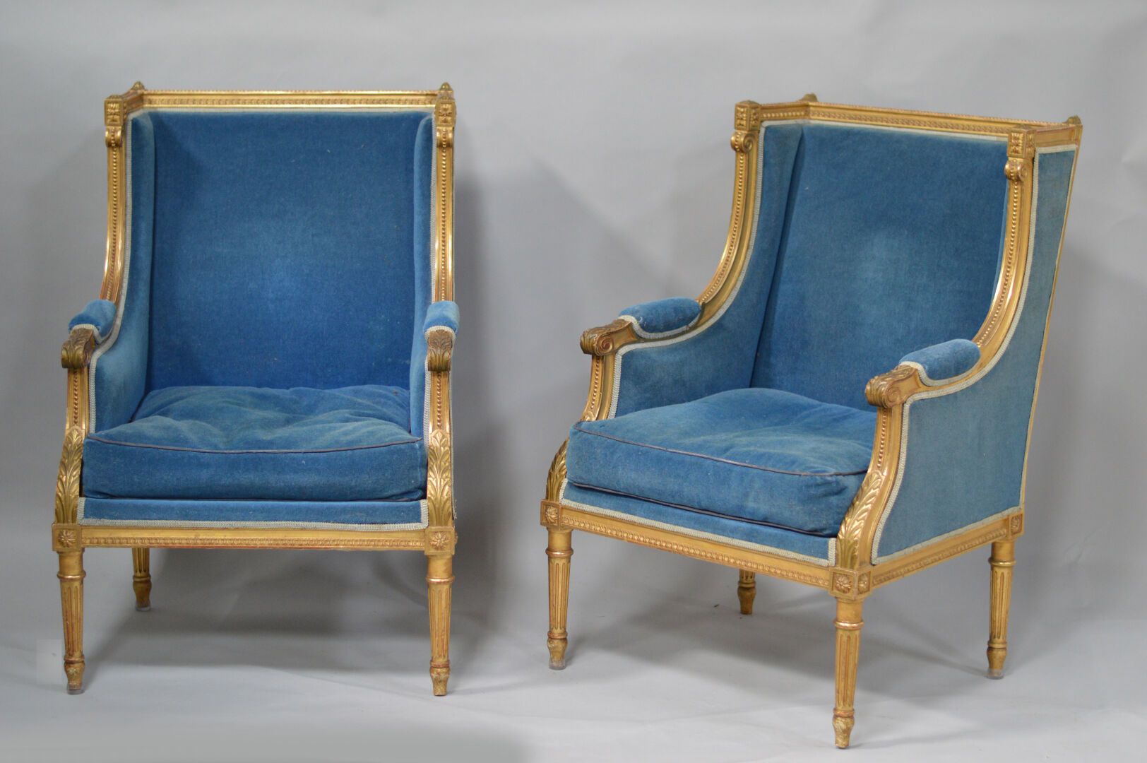 Null 一对路易十六风格的模制、雕刻和镀金的木制贝格，蓝色天鹅绒装饰
20世纪初
H.102 - W. 70 - D. 70厘米