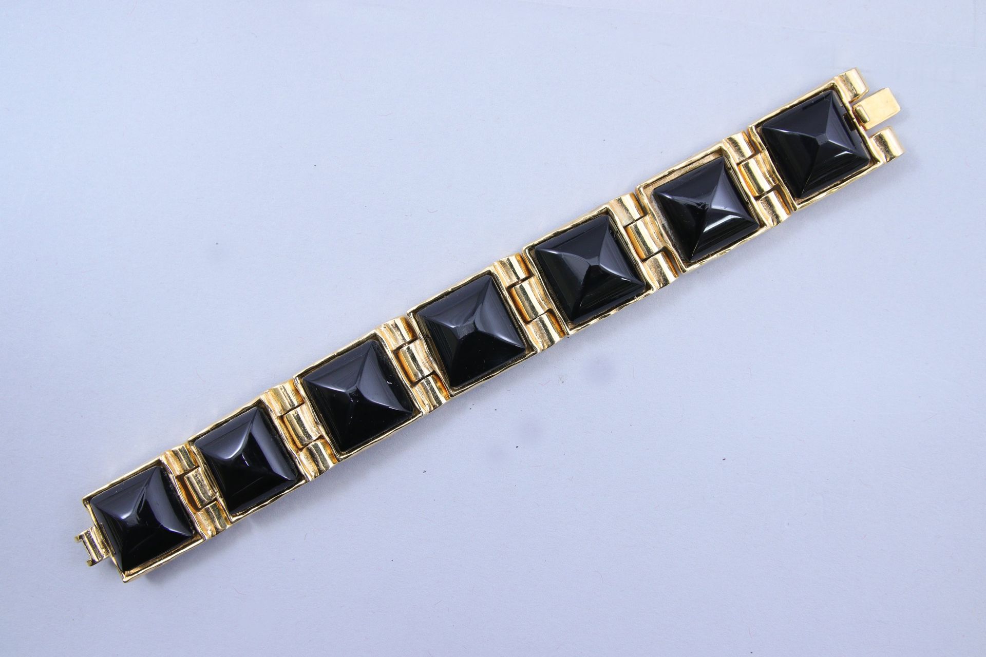 Null 香奈儿 
铰接式手镯 

鎏金金属，由七个四角形链节组成，上面装饰着黑色树脂凸圆形宝石。 
有签名和编号的 "429"。

长18.5厘米。