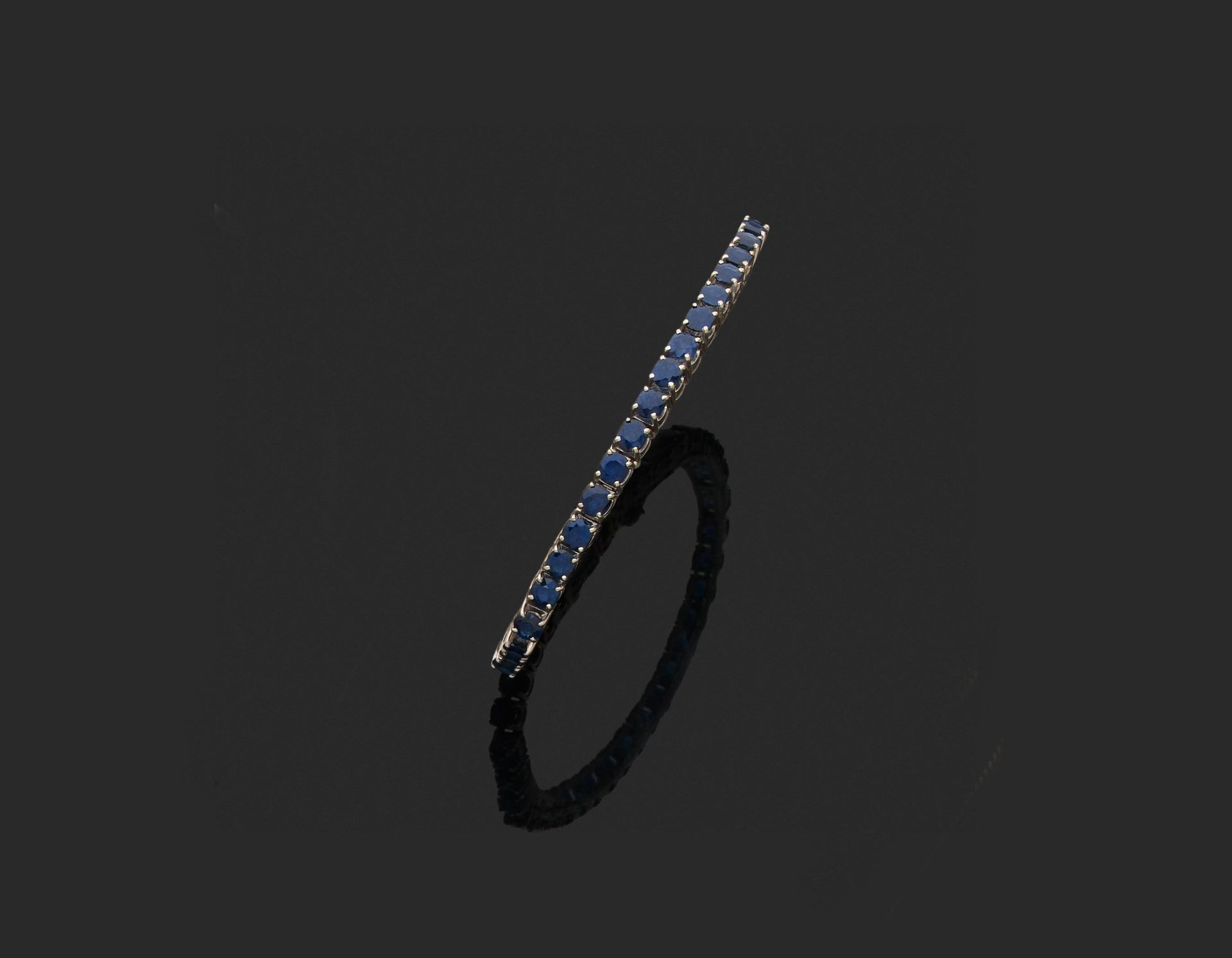 Null 法国作品 
铰链式手镯 

750千分之一白金，镶嵌一排38颗圆形蓝宝石。 

长约18厘米。 
毛重：22.2克。