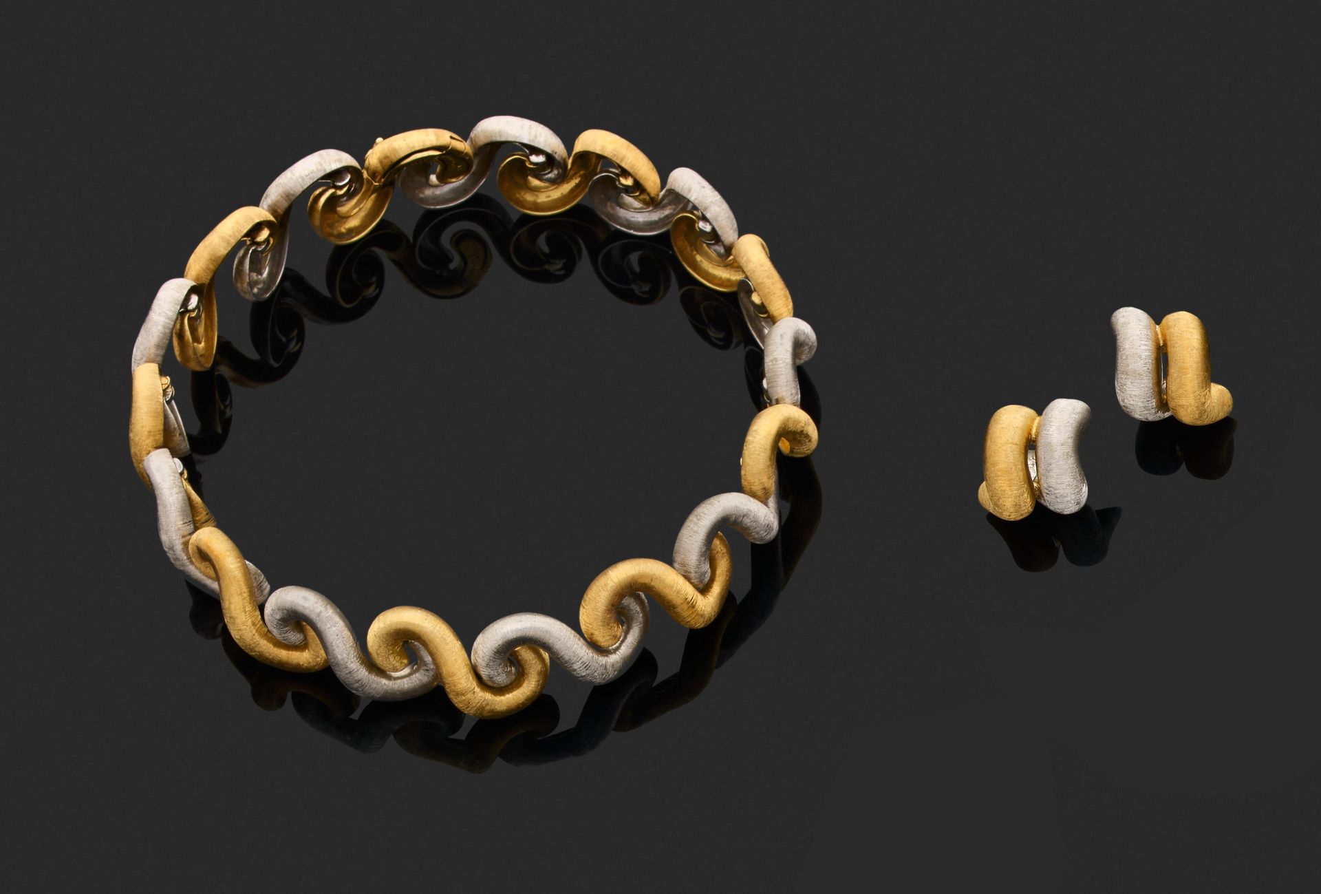 Null 布凯拉蒂 
项链和一对耳环 

750千分之一金双色，雕刻并镶嵌有 "波浪 "图案。 
已签名。适用于穿孔耳朵的系统。

项链长33厘米。
耳环的高度&hellip;