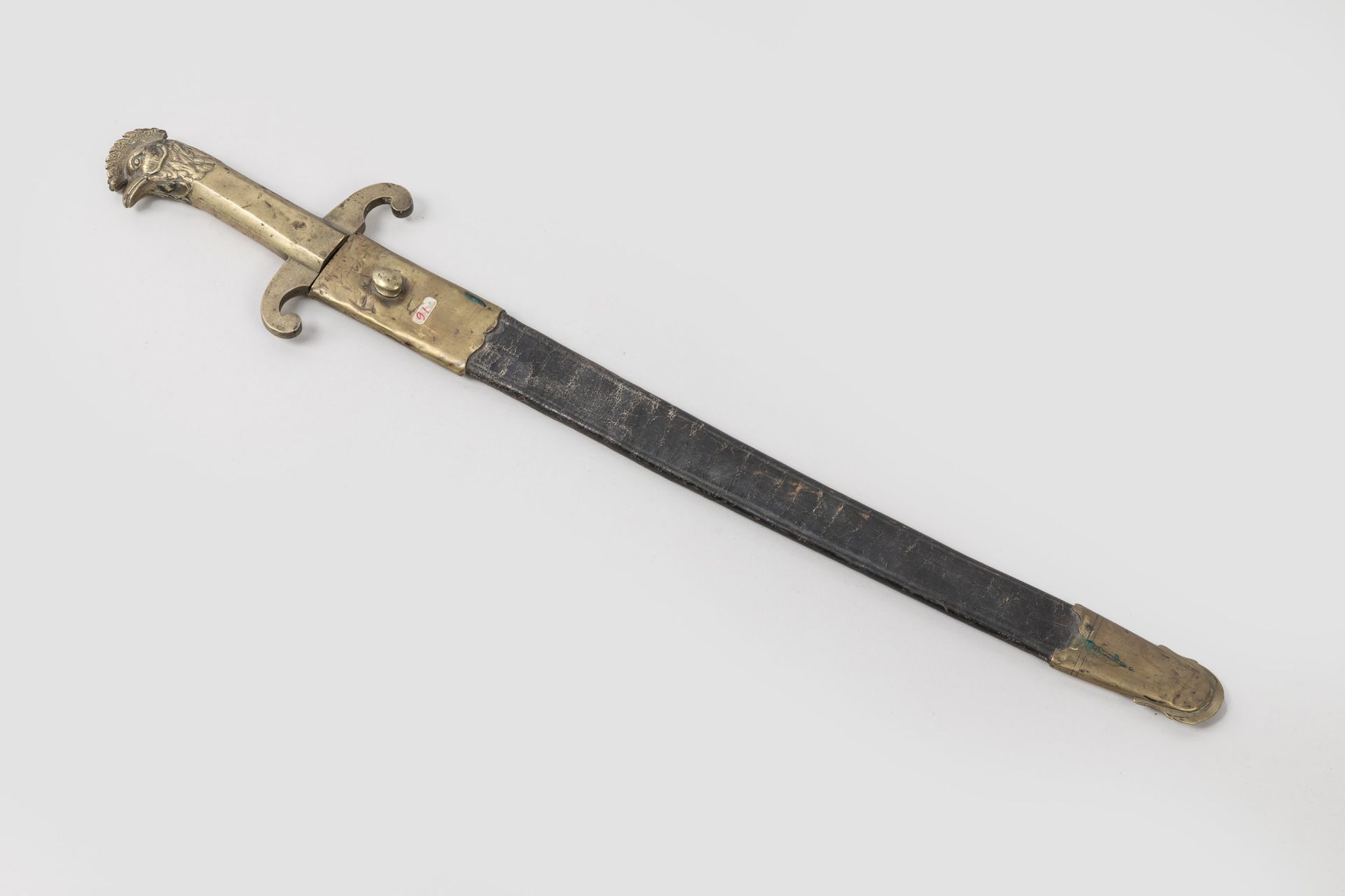 Null 军刀

 青铜公鸡头剑柄，有两个向下弯曲的剑身。钝背刀刃。皮革剑鞘上有两个黄铜配件。 

18 世纪晚期至 19 世纪早期。 

A.B.E.