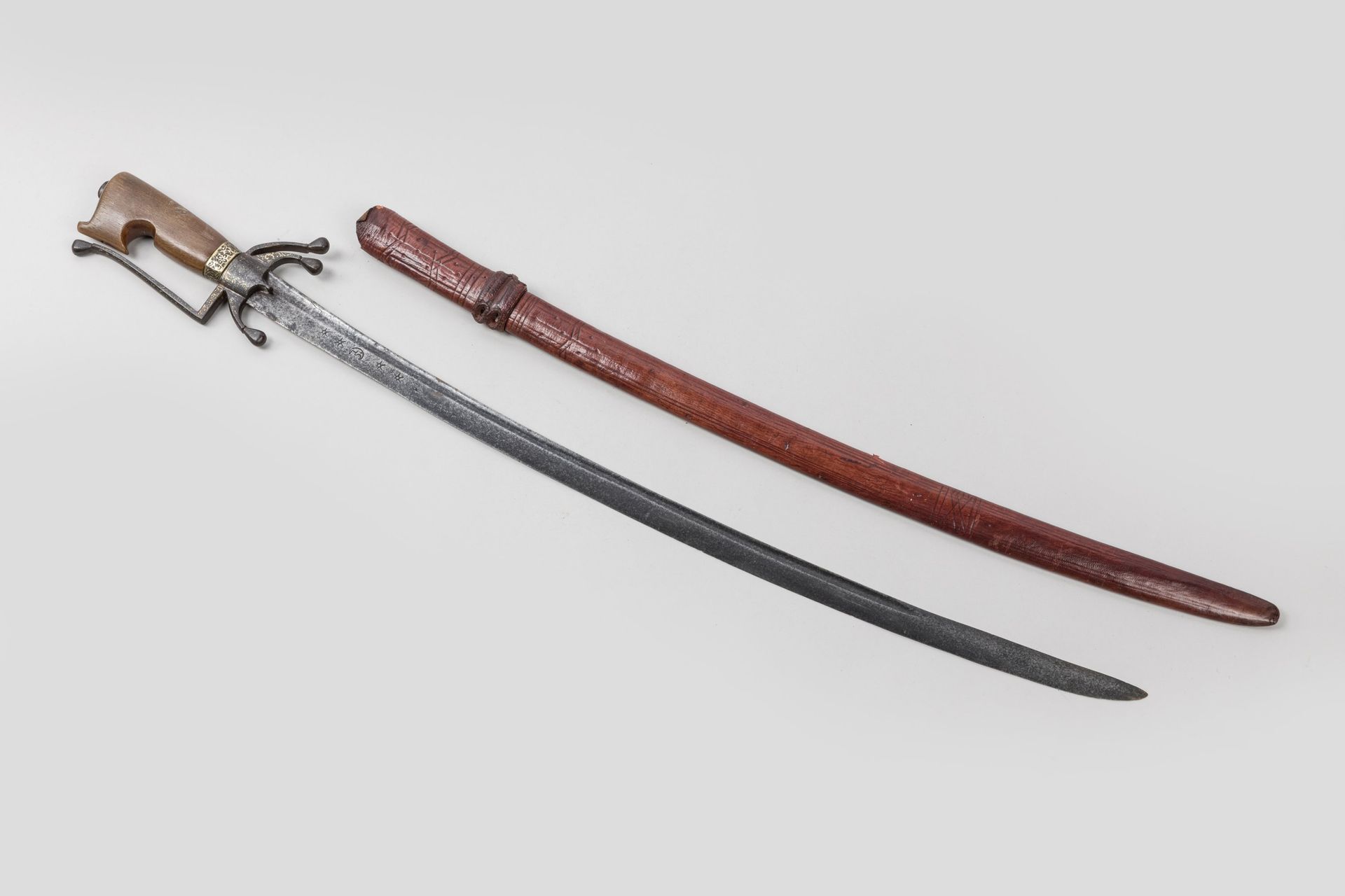 Null 摩洛哥军刀，被称为 "Nimcha"。 

浅色牛角手柄。金色大马士革锻铁支架、单支剑柄和三个向下弯曲的栓式剑节。弧形刀刃，平背、反刃、空侧，刀踵处有&hellip;