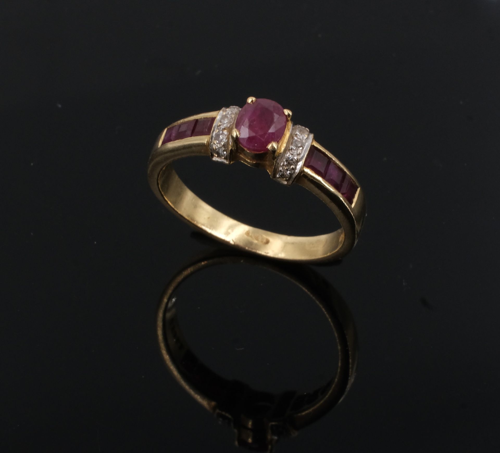 Null Ring aus Gelbgold, besetzt mit kalibrierten Rubinen, davon ein zentraler in&hellip;
