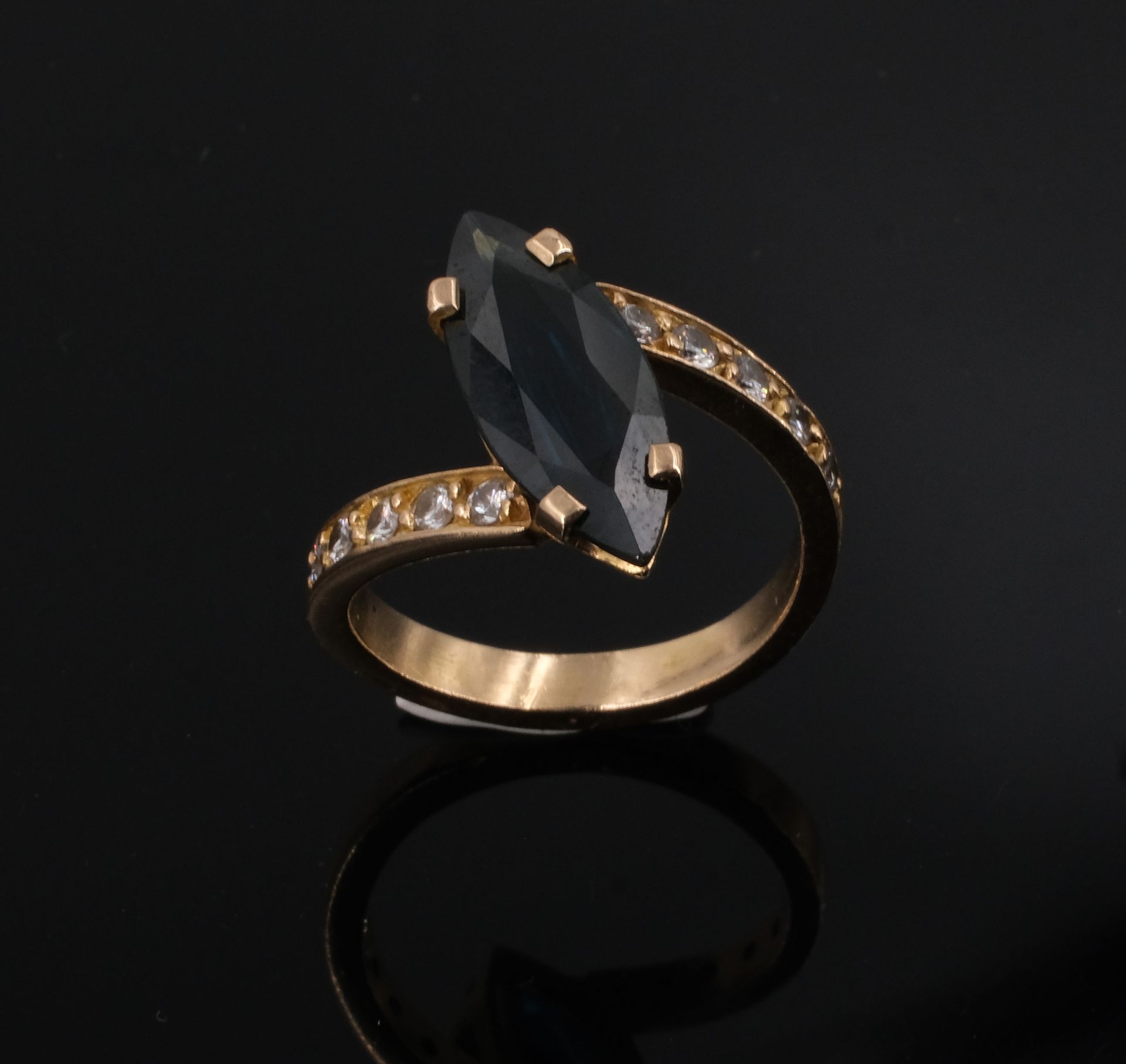 Null Ring aus Gelbgold, besetzt mit einem blauen Stein, der von kleinen Diamante&hellip;