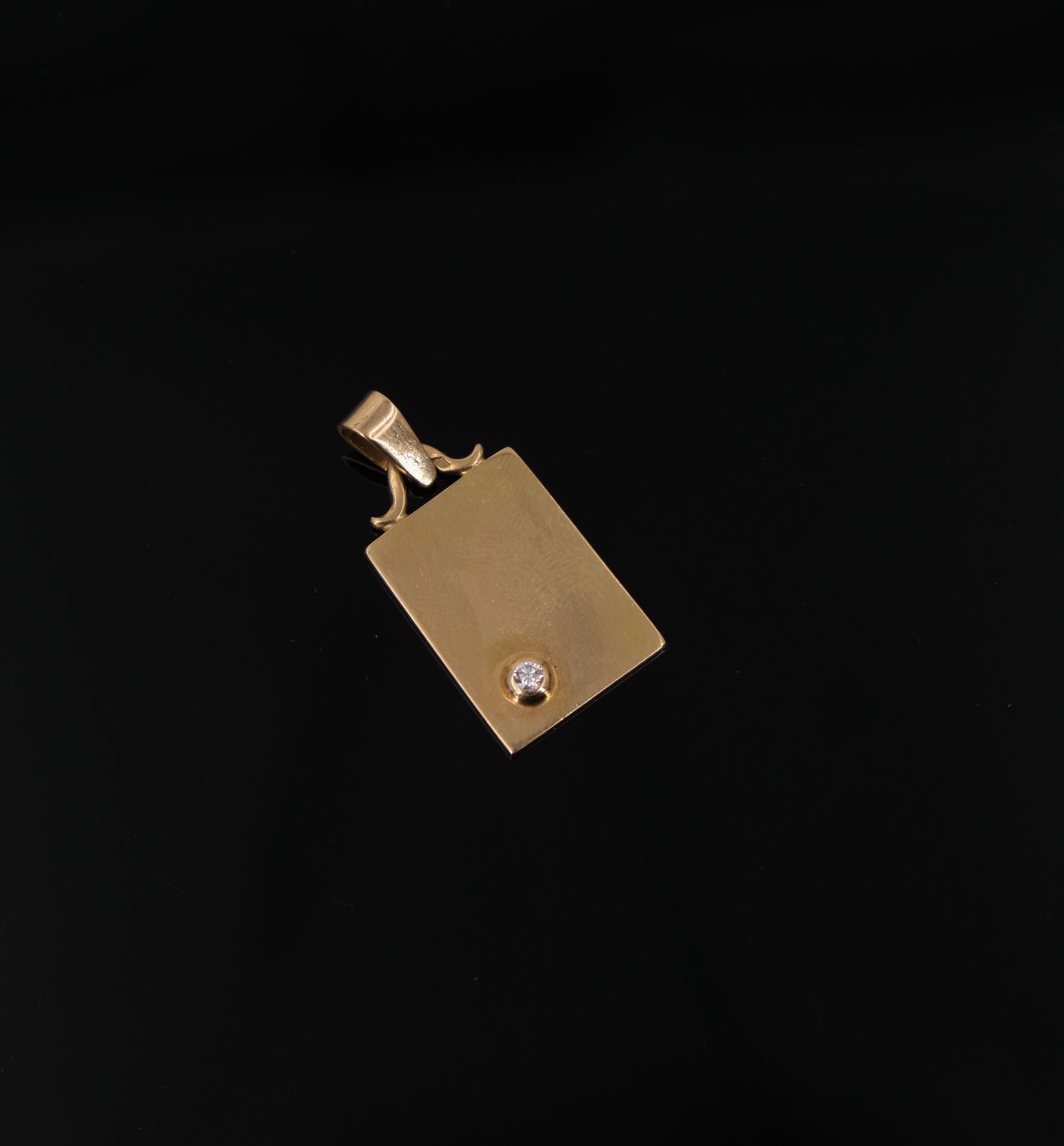 Null Pendentif rectangulaire en or jaune serti-clos d'un diamant. PB : 9,7 g.