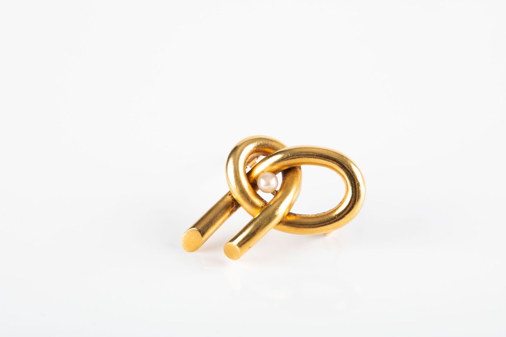 Null Spilla a filo tondo in oro giallo che forma un nodo centrato da una perla p&hellip;