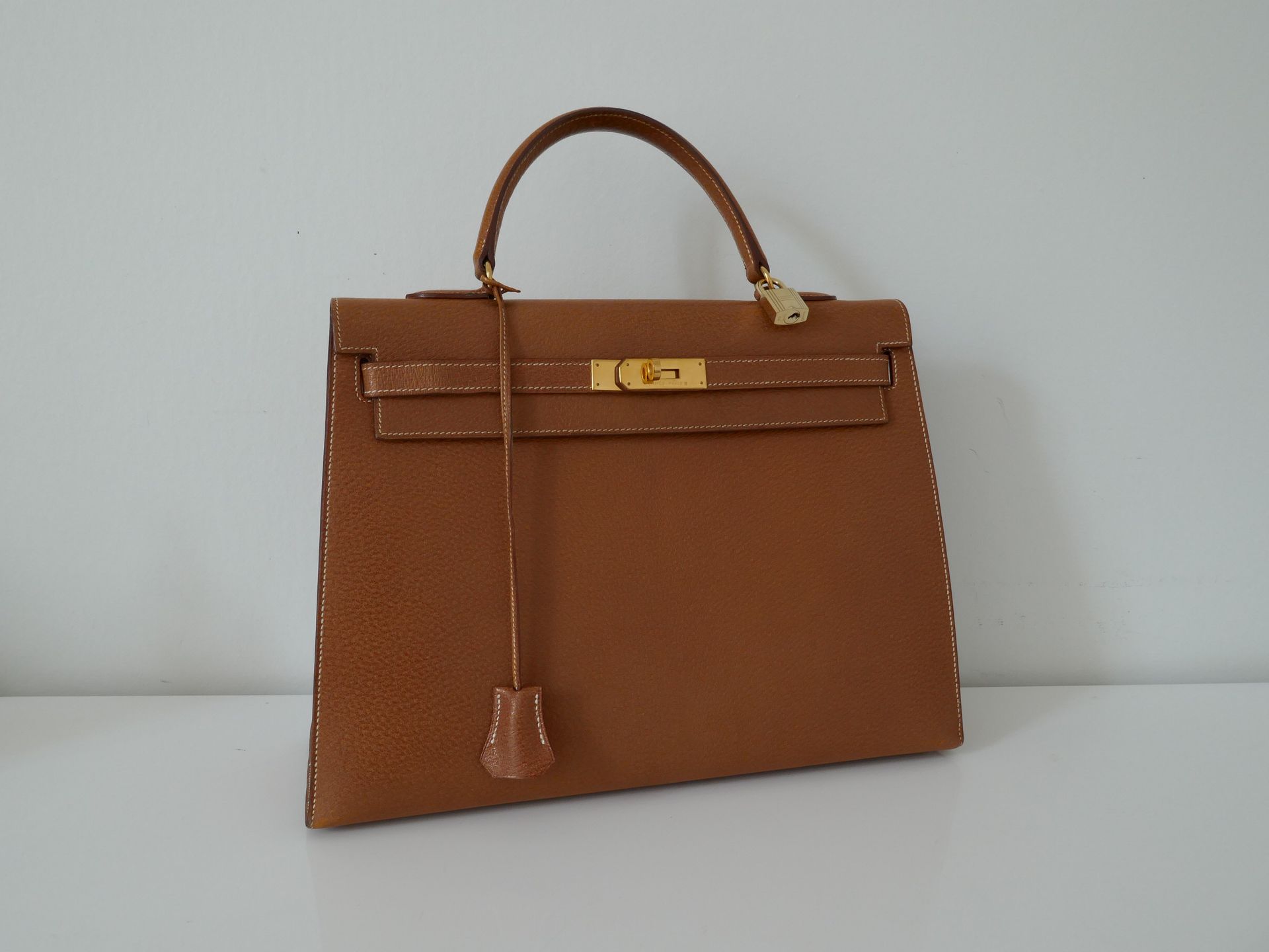 Null HERMES Paris
Kelly Gold" bag (35) in hard pigskin grained leather. Gold sad&hellip;