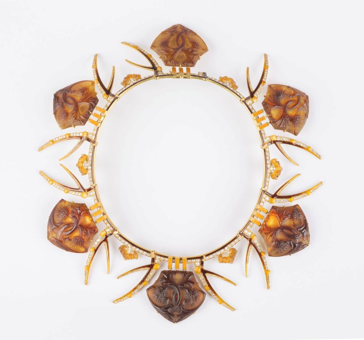 Null 勒内-拉里克(1860-1945)
"蓟花"。约1908年
奢华的黄金和钻石衔接的刚性吊坠，由六个五角形的琥珀色模压玻璃板组成，上面装饰着两朵交织在一&hellip;