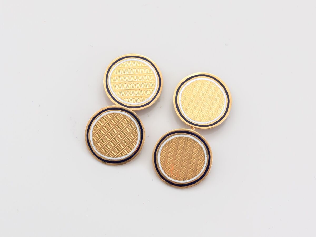 Null 一对750°/°°(18K)黄金双圆盘袖扣，饰有扭索饰纹和珐琅片。重 6.20 克。直径 13.7 毫米