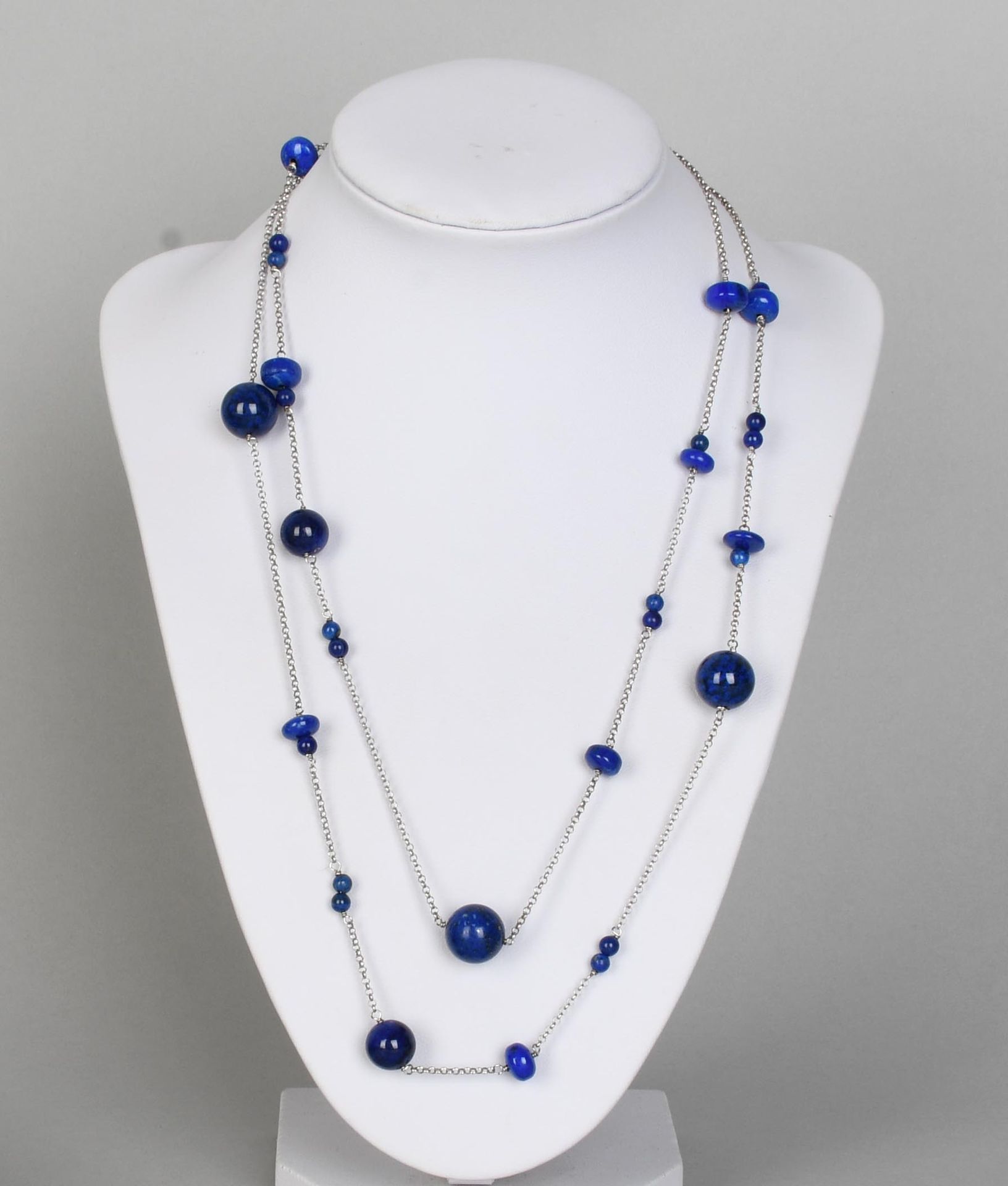 Null Juwel

Lange Halskette aus Lapislazuli-Perlen und Silber.