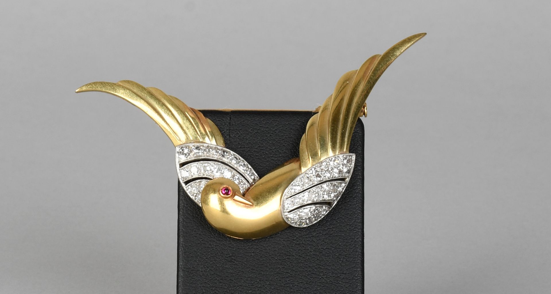 Null 瑰宝

小鸟形状的胸针，黄金和白金，镶嵌钻石和凸圆形红宝石。总重量：+9,9克。