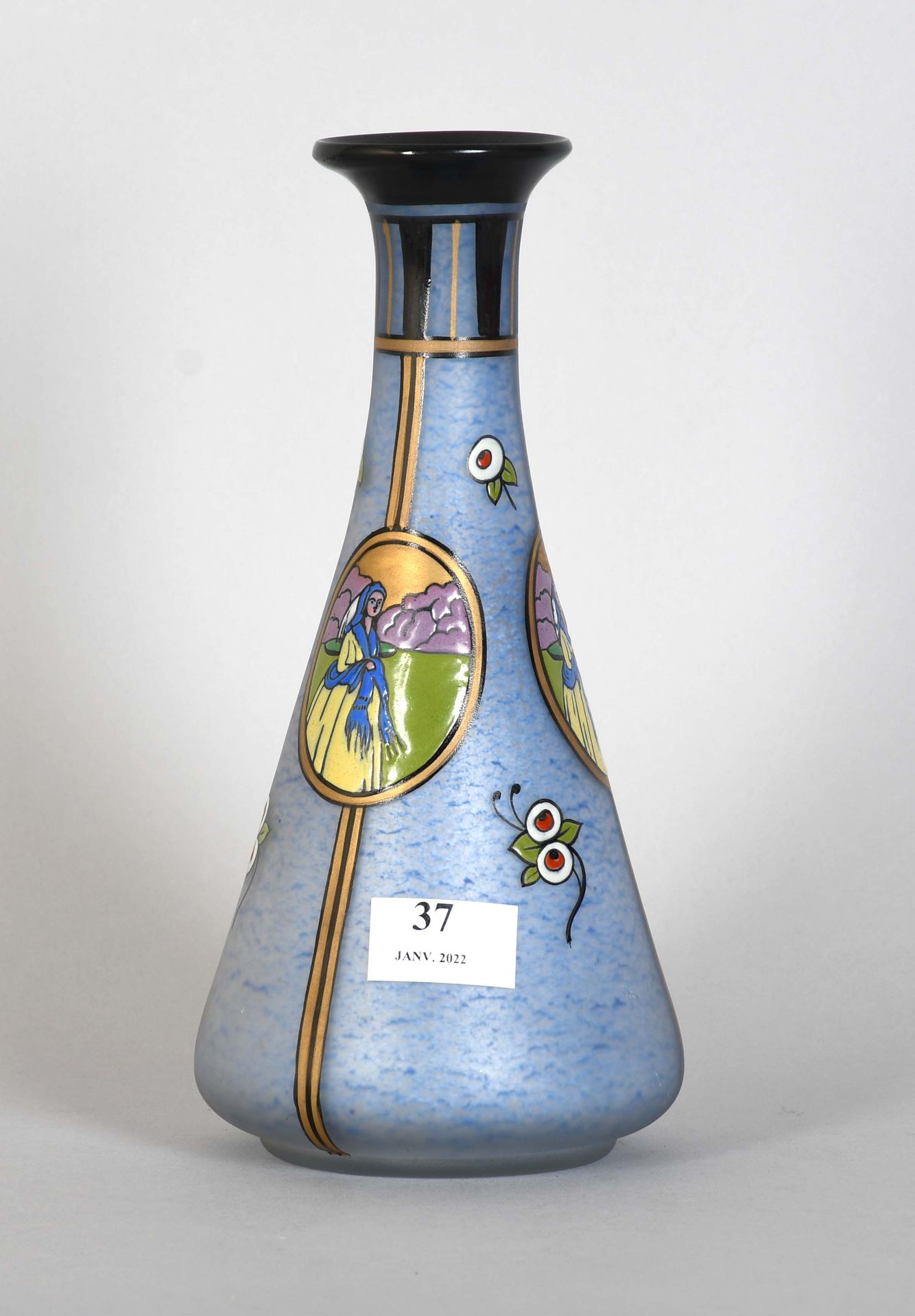 Null 剑桥大学

一个蓝色着色玻璃的装饰艺术花瓶，有多色珐琅装饰的奖章和花朵。签名。

高度：26厘米。