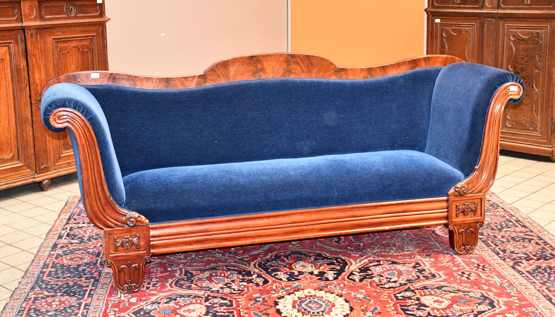 Null 一个19世纪查理十世的桃花心木模制沙发，雕刻着公羊头的图案

长度：227厘米。