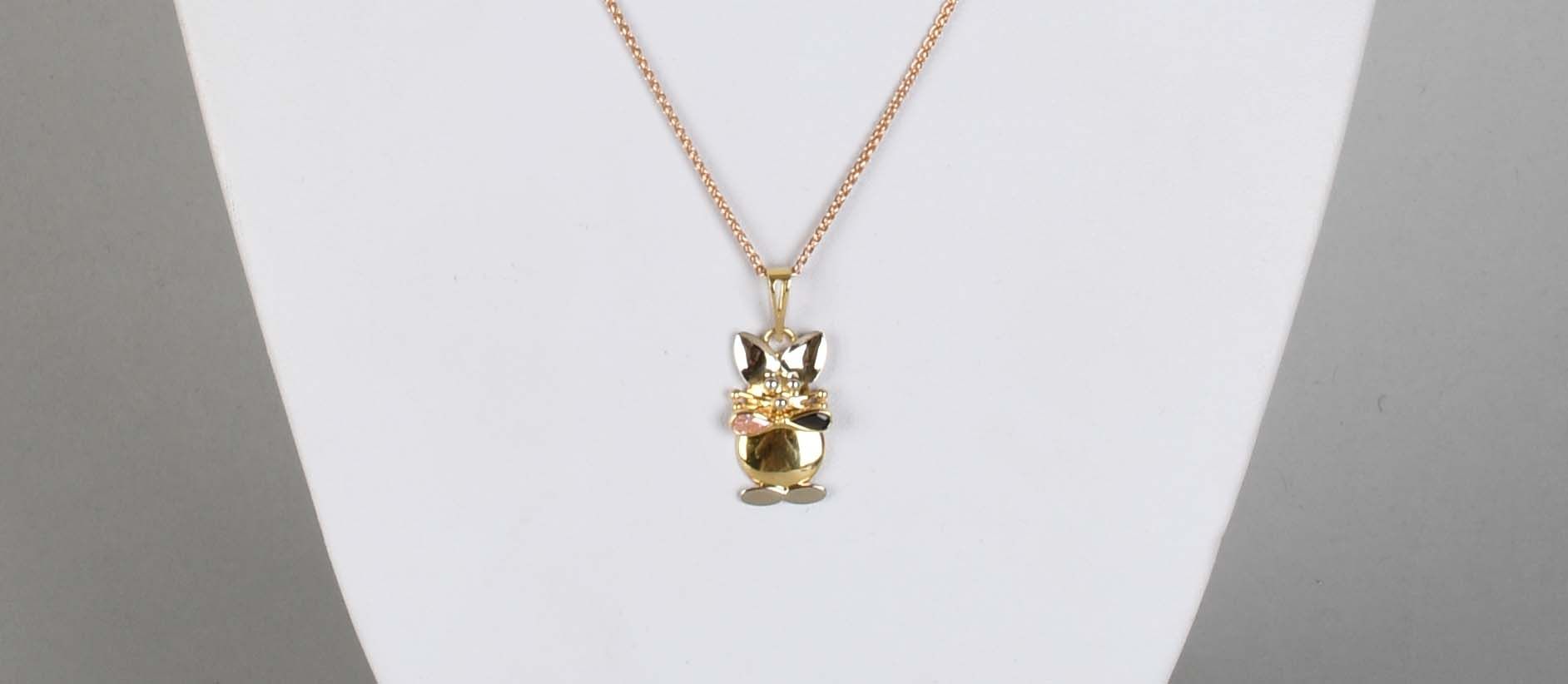 Null 瑰宝

猫形吊坠，18K黄金，镶嵌两颗彩色宝石，18K玫瑰金链条。总重量：+5克。