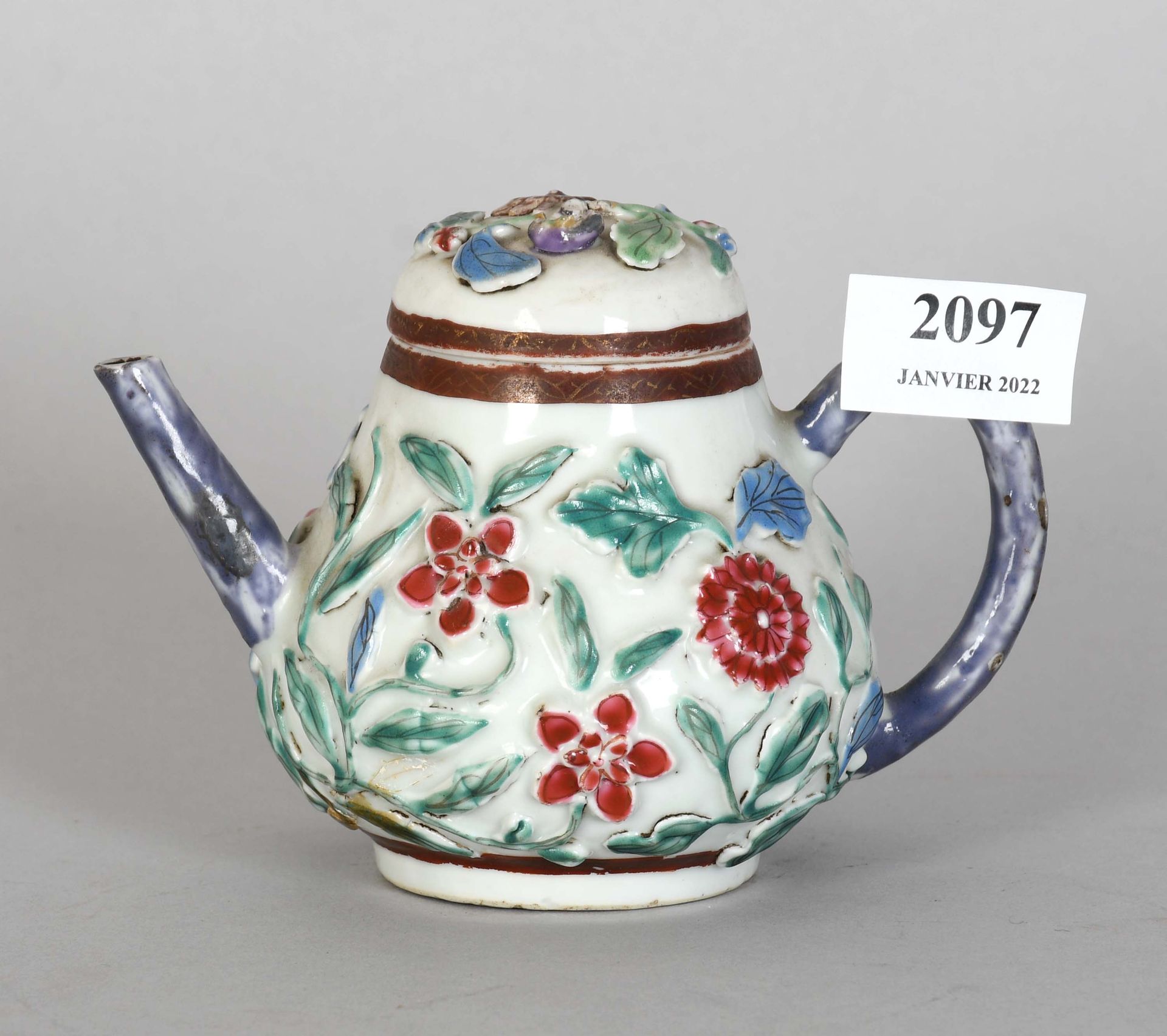 Null 中国

小型多色瓷茶壶，浮雕花卉装饰。Fretel受损。头发。

高度：11厘米。