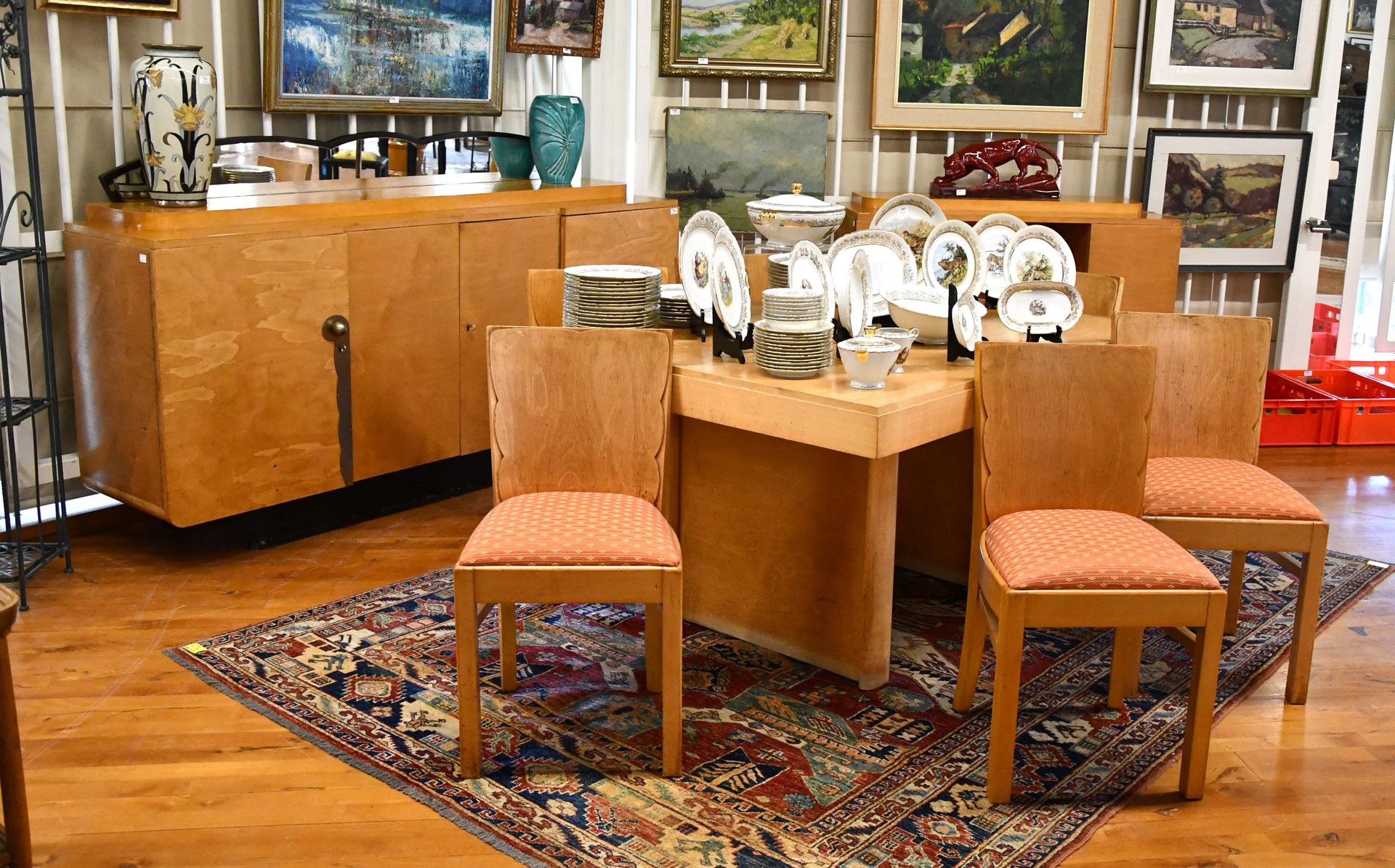 Null 浅色木饰面的装饰艺术餐厅

一个带四门的餐具柜，一个支架，一张桌子和六把椅子。