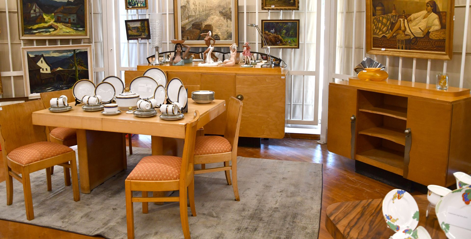 Null 浅色木饰面的装饰艺术餐厅

一个带四门的餐具柜，一个支架，一张桌子和六把椅子。