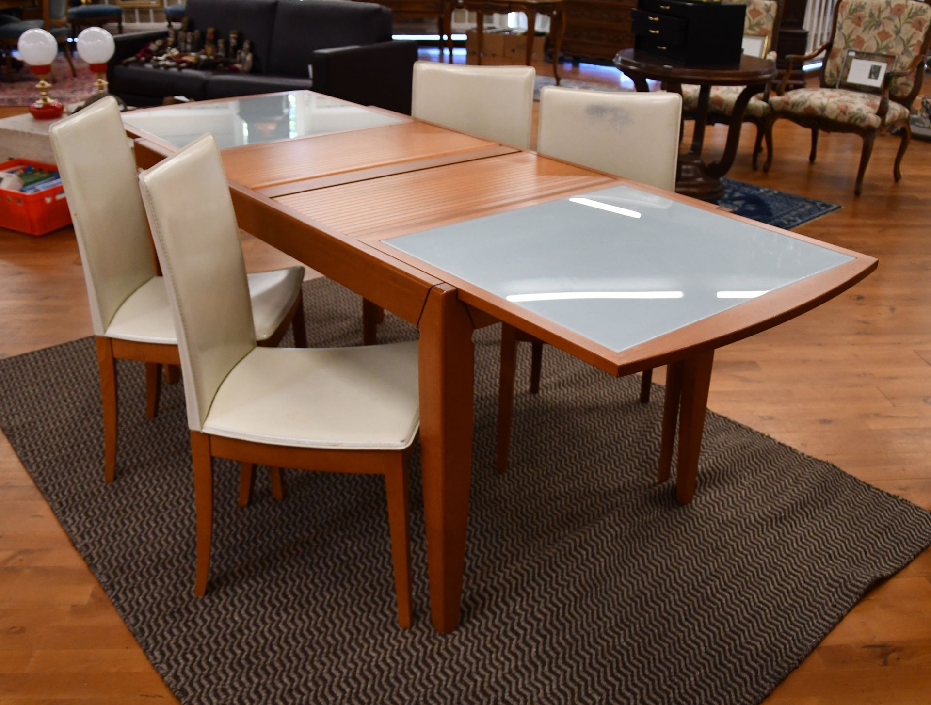 Null 卡利加里斯

当代的餐桌有缎面玻璃架和翻盖系统，四把椅子有皮革靠背和座椅。