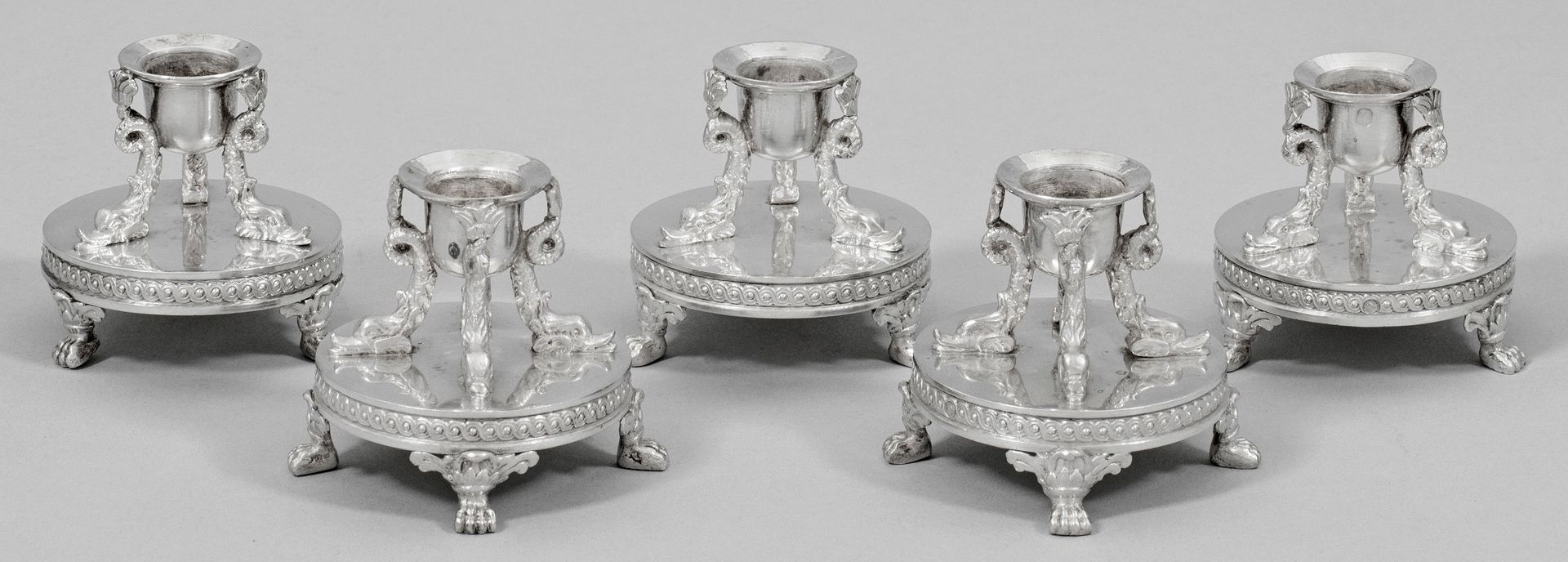 Null Jeu de cinq petits chandeliers de table décoratifs Empire en argent. Un soc&hellip;