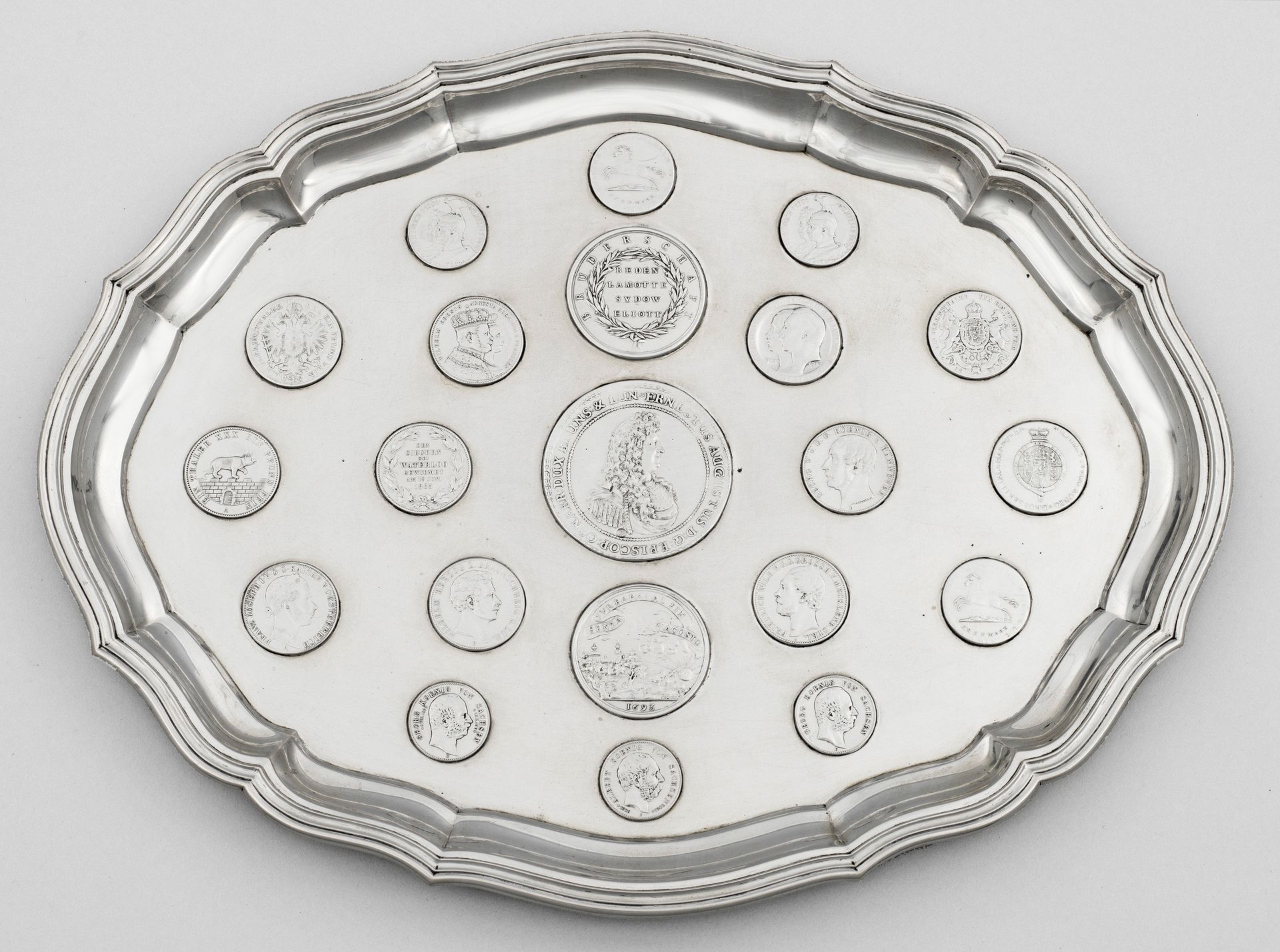 Null 具有代表性的银币托盘。四个球形底座上有椭圆形的微模制镜面，镜面与弧形、缓缓升起的多棱形边缘相吻合。光滑的中央摆放着从 1680 年到 1904 年共计&hellip;
