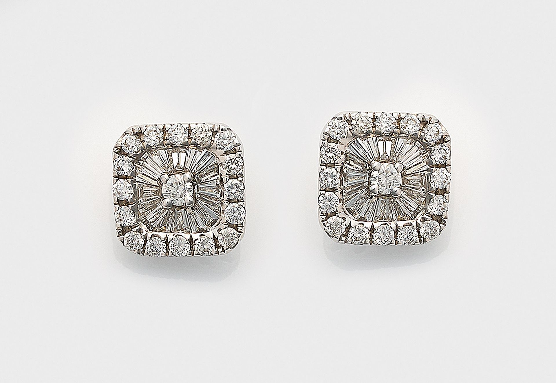 Null 一对优雅的白金钻石耳环，镶嵌明亮式切割钻石和梯形切割钻石，共计约 0.66 克拉（G-H/si）。总重约 2.55 克。
一对 18K 白金耳环，镶嵌&hellip;