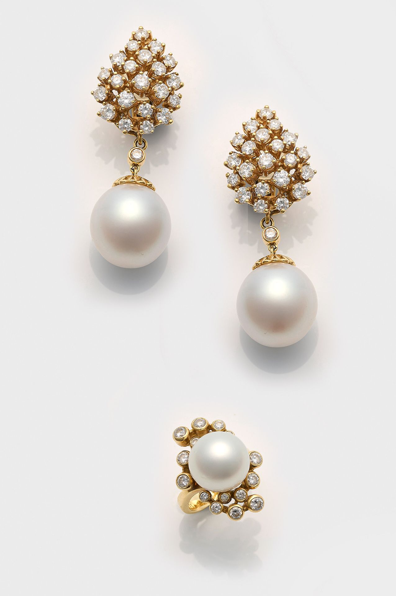 Null Leicht 制作的优雅的南海珍珠和明亮式切割钻石耳环一对，配有相应的戒指。每枚耳环均镶嵌一颗约 13 - 15 毫米的白色南海珍珠，呈现绚丽多彩的粉&hellip;