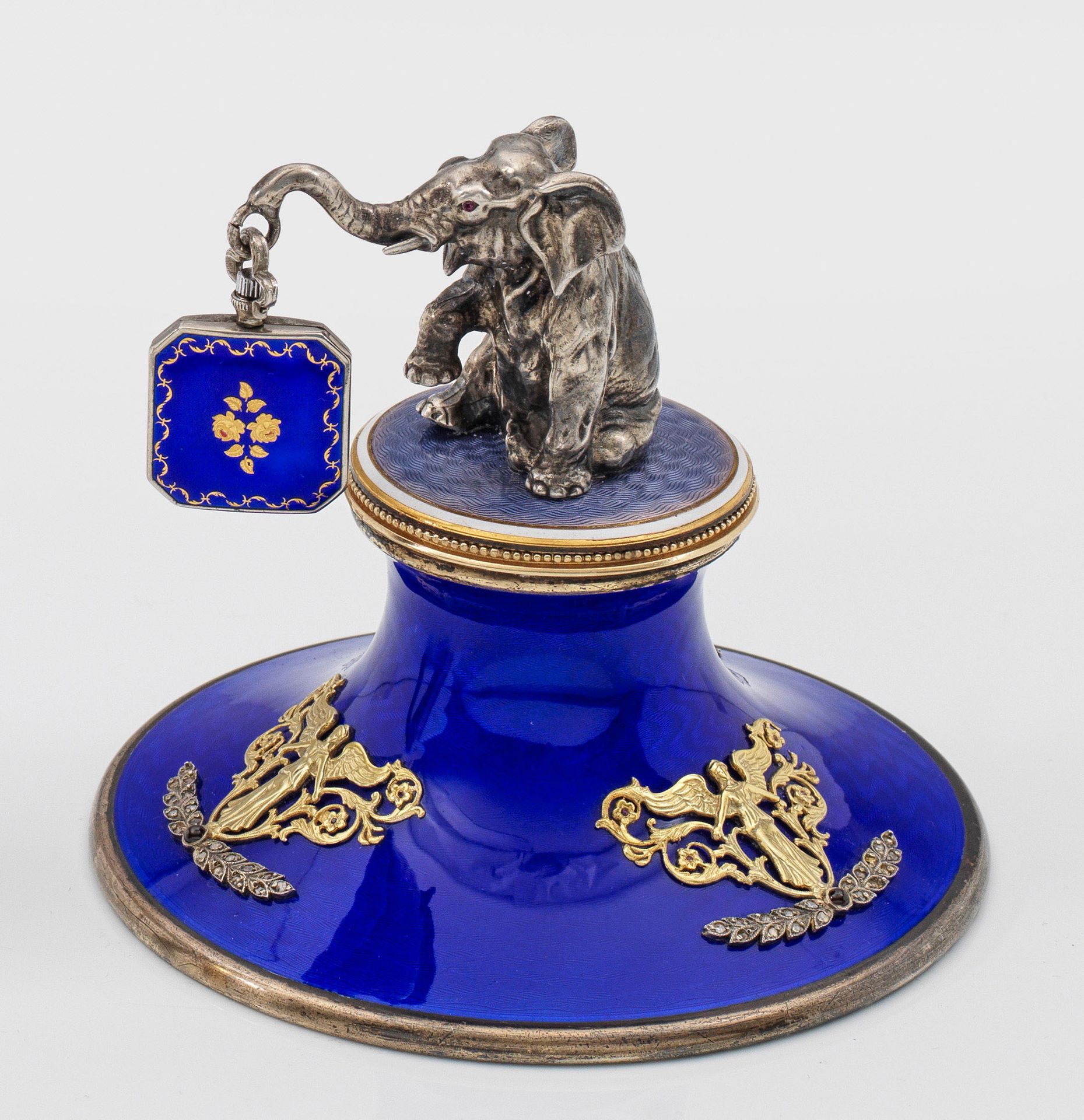 Null 卡尔-法贝热（Karl Fabergé）风格的形象表托。银质，部分镀金和珐琅。圆柱形底座，顶部施淡紫色珐琅彩。上面有一个雕刻完整的大象坐像，眼睛用凸圆&hellip;