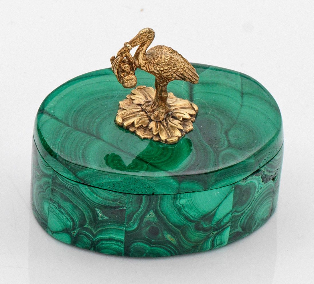 Null 孔雀石盒，带有卡尔-法贝热（Karl Fabergé）风格的形象把手。银质，镀金。椭圆形盒身，直壁。平盖上饰有叶形浮雕，浮雕的鹳鸟嘴里衔着一个孩子。标&hellip;