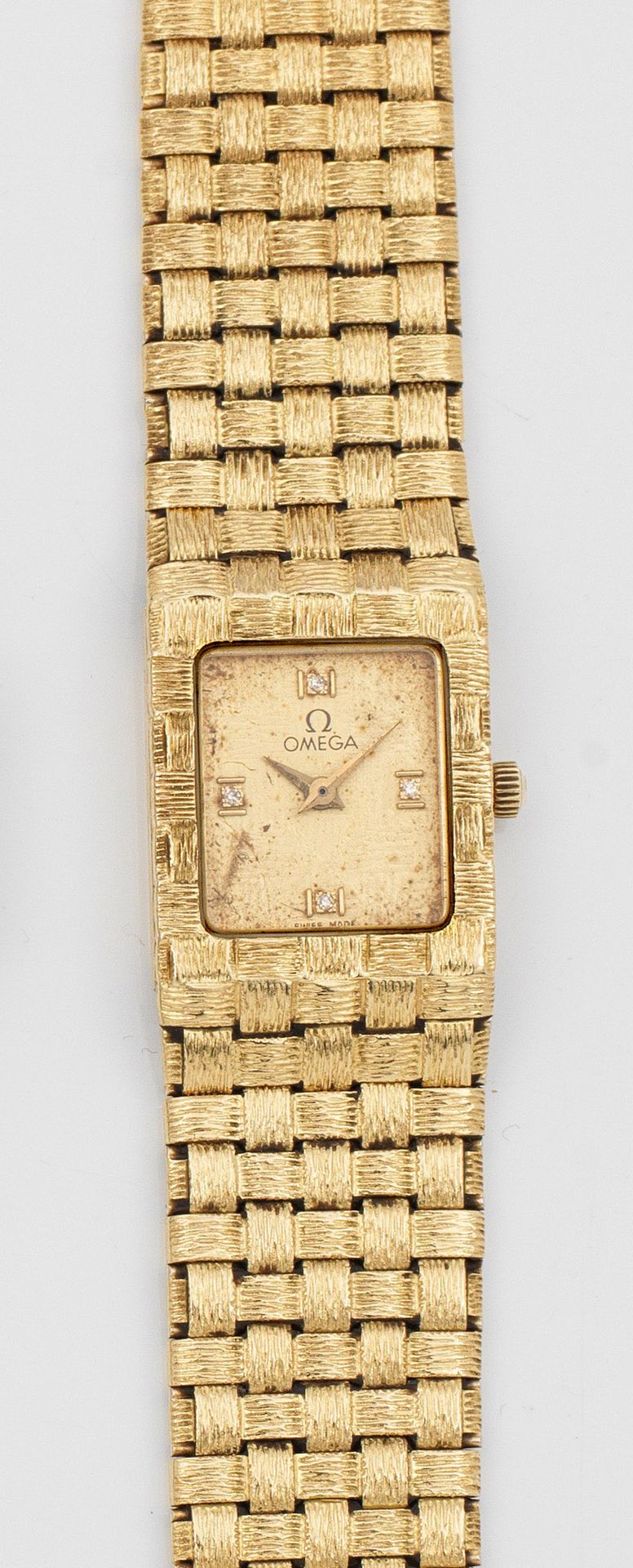 Null 欧米茄 1970 年代黄金女装腕表，标有 750 字样。 长方形表壳，表盘饰有钻石刻度和矛形指针。表壳和过渡表链采用凸起编织设计，配有折叠表扣。机械机&hellip;