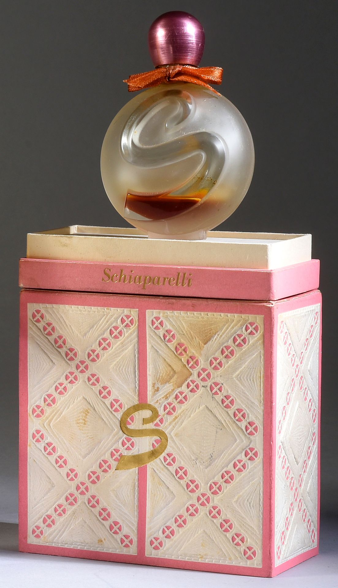 Schiaparelli - «S» - (1961) 
呈现在用粉色和白色浮雕纸覆盖的纸板箱中，标题为无色磨砂玻璃弧形奖章瓶，上面有浮雕的S标志，有粉色金属盖&hellip;