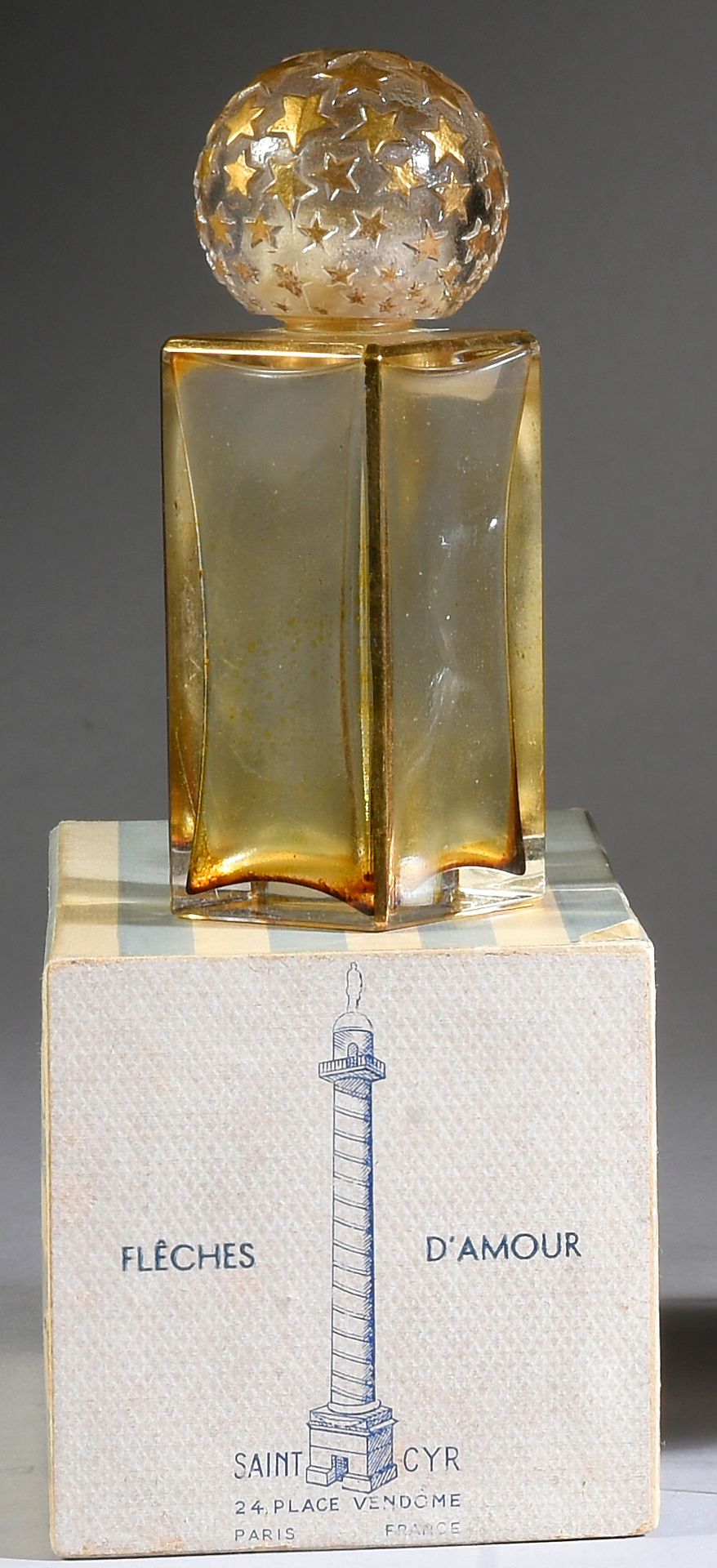 Claude Saint Cyr - «Flèches d'Amour» - (1945) 
无色的玻璃瓶被压成立方体柱状，上面涂有金漆，盖子是球形玻璃，上面有&hellip;