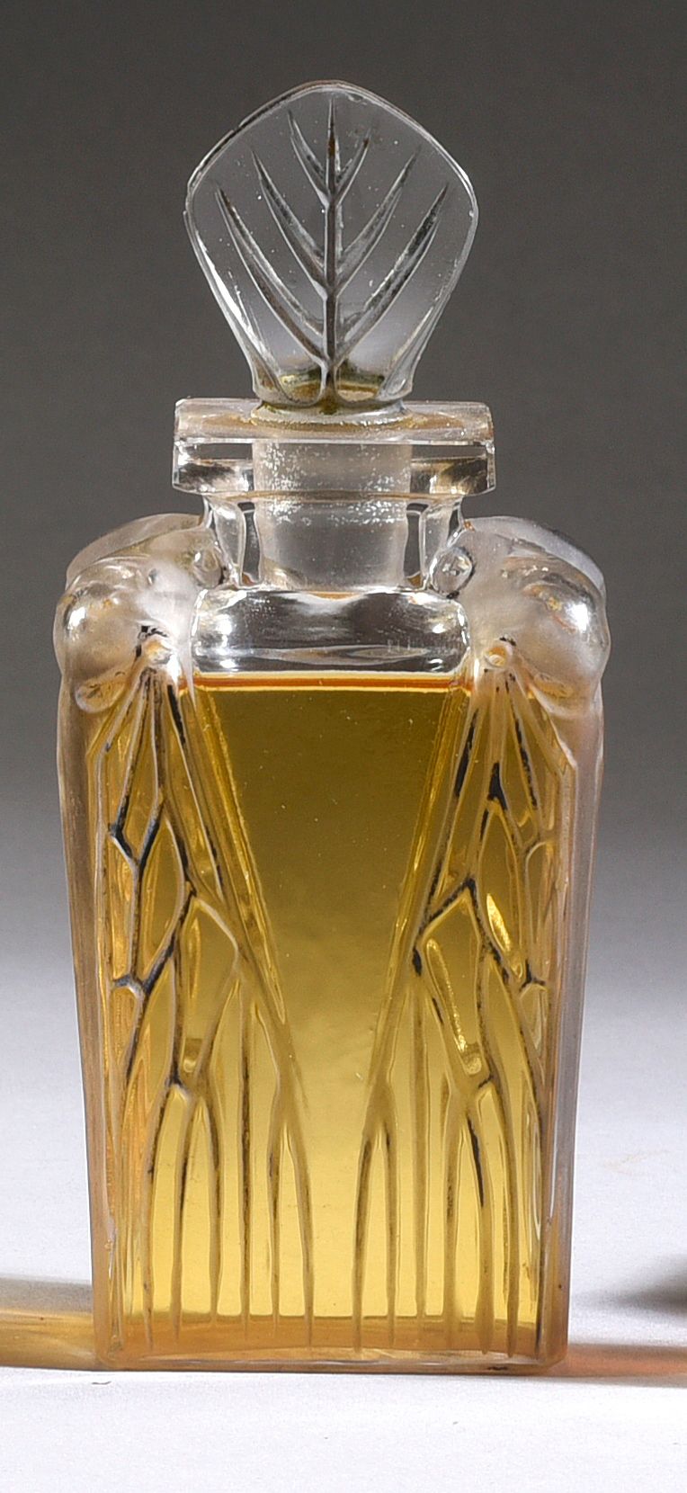 ROGER & GALLET - «Cigalia» - (1912) 优雅的无色压制玻璃自然主义酒瓶，略微磨砂，横截面为长方形，其立方体的瓶身装饰着一只折翼的&hellip;