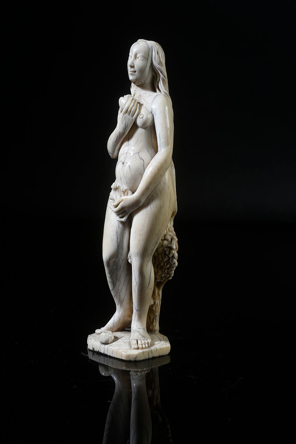 Null 象牙圆雕的夏娃。她以圆润的身体站立，右手拿着知识的果实，左手在前面拿着藤叶。
德国，17世纪下半叶 H．19厘米 - 重量：0,227公斤（底部有少量&hellip;