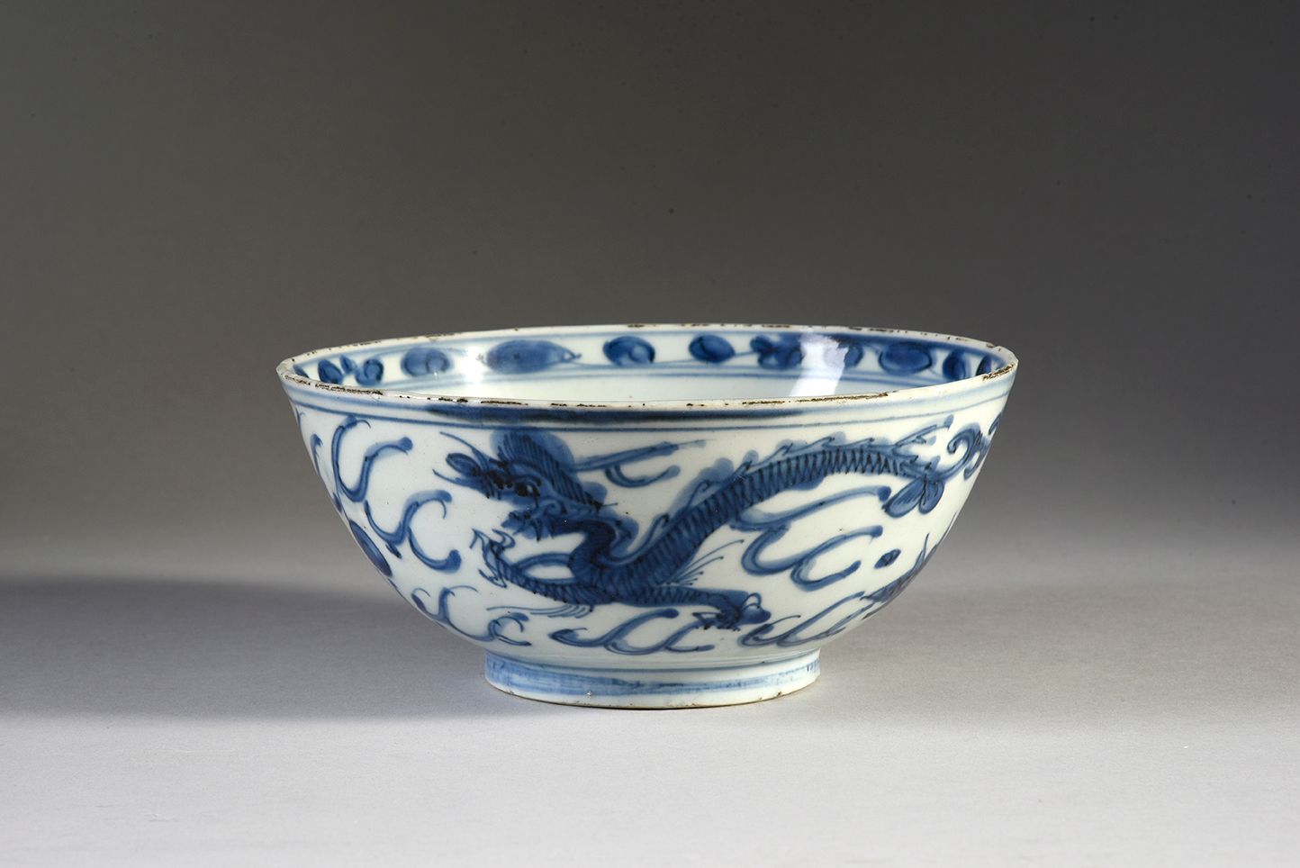 CHINE - XVIIe siècle 瓷碗，釉里红装饰有凤凰、莲花和波浪，内部装饰有鹿的纹章和叶子的楣。(唇部有缺口，底面有烧制裂纹)
D.17.5厘米