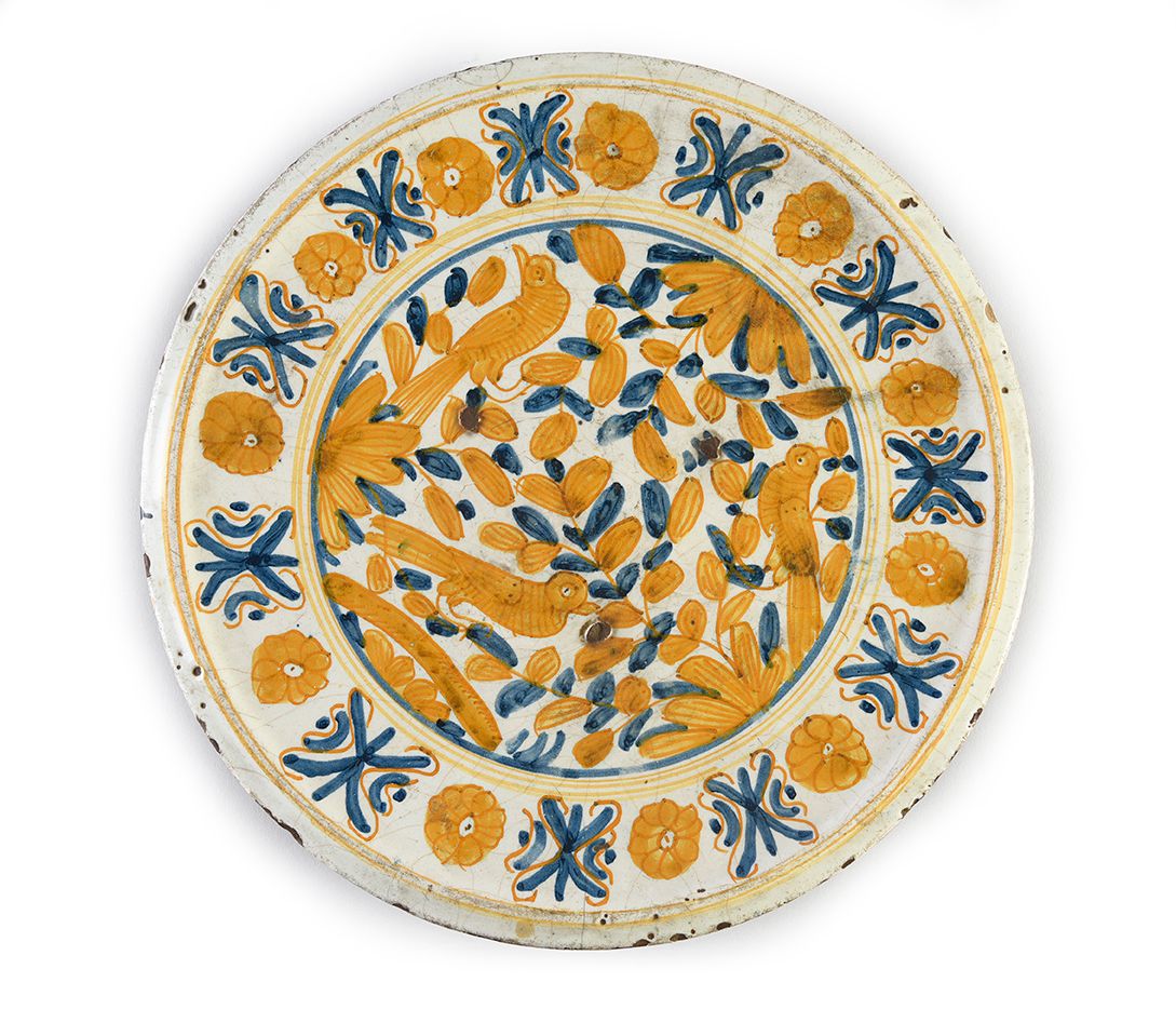 Null 17世纪意大利陶器老千，可能是利古里亚
，中央有蓝色和赭石的装饰，是枝头的鸟儿，周围有棕榈树和风格化的花头穿插，反面是几何图案和风格化的植物，缺少基座&hellip;