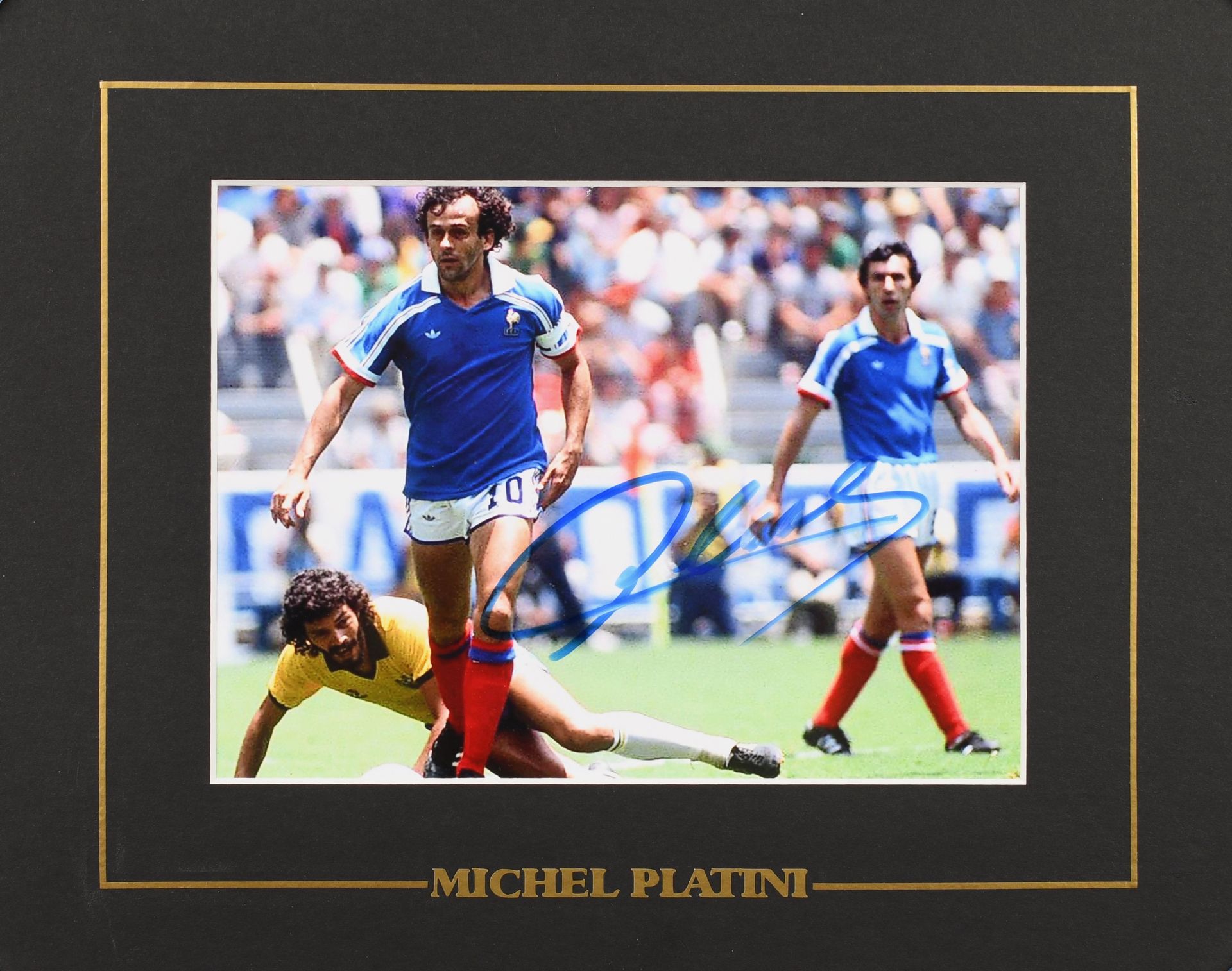 Null 米歇尔-普拉蒂尼。1986年世界杯1/4决赛对阵巴西时，身穿法国国家队球衣的球员亲笔签名的照片。彩色照片。格式为15x20厘米，24x30厘米的框架。