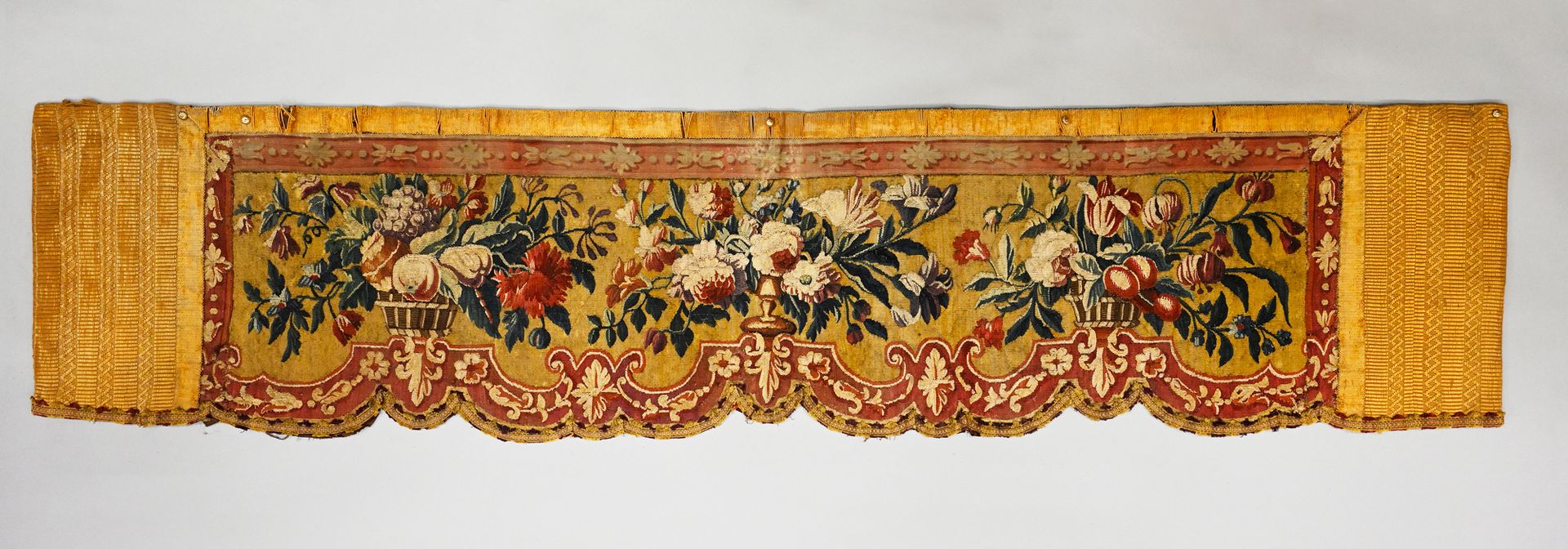 Null 挂毯床坡，路易十四时期，羊毛和丝绸挂毯，在烟草背景上装饰着装着罂粟和水果花束的篮子。
加了边框和衬布，44 x 200厘米。