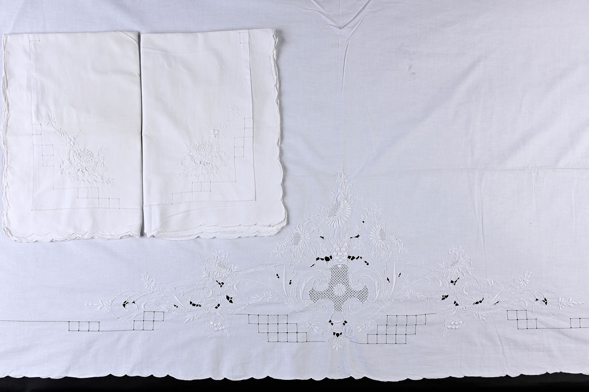 Null 一套刺绣的床单和被单，20世纪中期。
床单和一对枕头套都是手工刺绣的，床单的背面是一个中央刻字和花束，精细的日工，边缘有扇形，枕头套的一个角上绣有一朵&hellip;