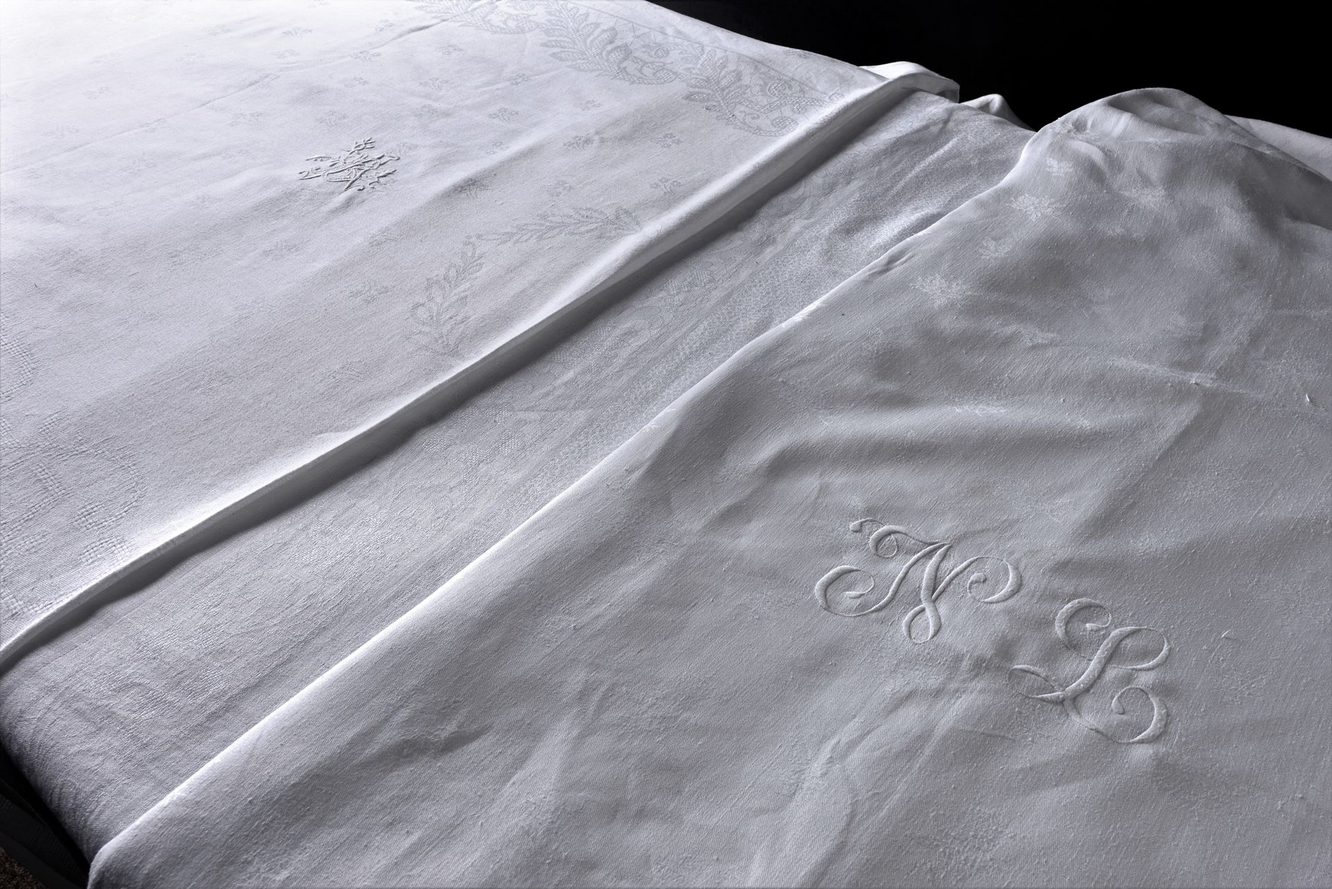 Null 三张大马士革桌布，20世纪上半叶。
棉质大马士革，一个有树叶装饰，绣有字母AB，尺寸为3.80 x 1.60米，一个有玫瑰装饰，绣有大字母NB，尺寸为&hellip;