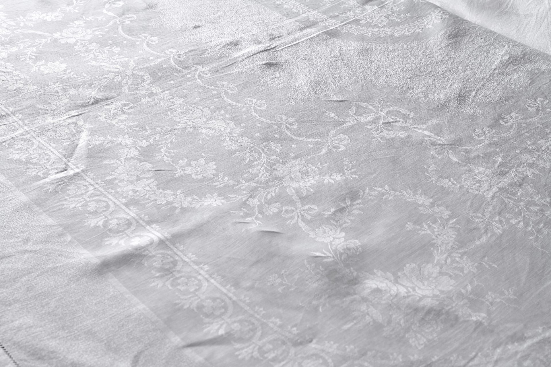 Null 带有打结丝带和玫瑰的大型锦缎桌布，20世纪初。
亚麻大马士革，宽边的打结丝带支撑着一个大的打结丝带，上面有落下的玫瑰花环，叶子和野玫瑰，桌布是缩小的图&hellip;